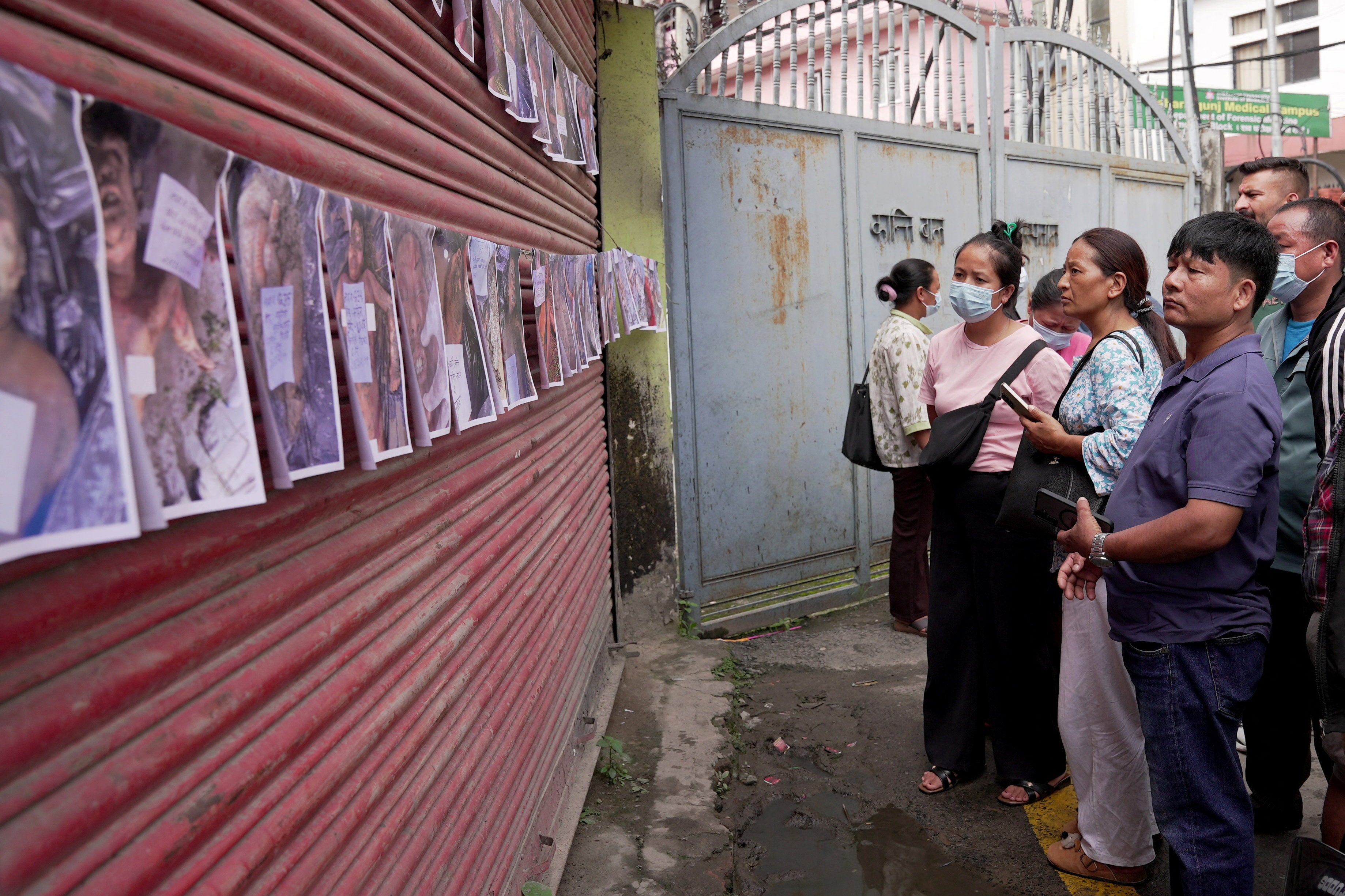People look at pictures of victims following flash floods and a mudslide, outside a mortuary of Tribhuvan University Teaching Hospital in Kathmandu, Nepal