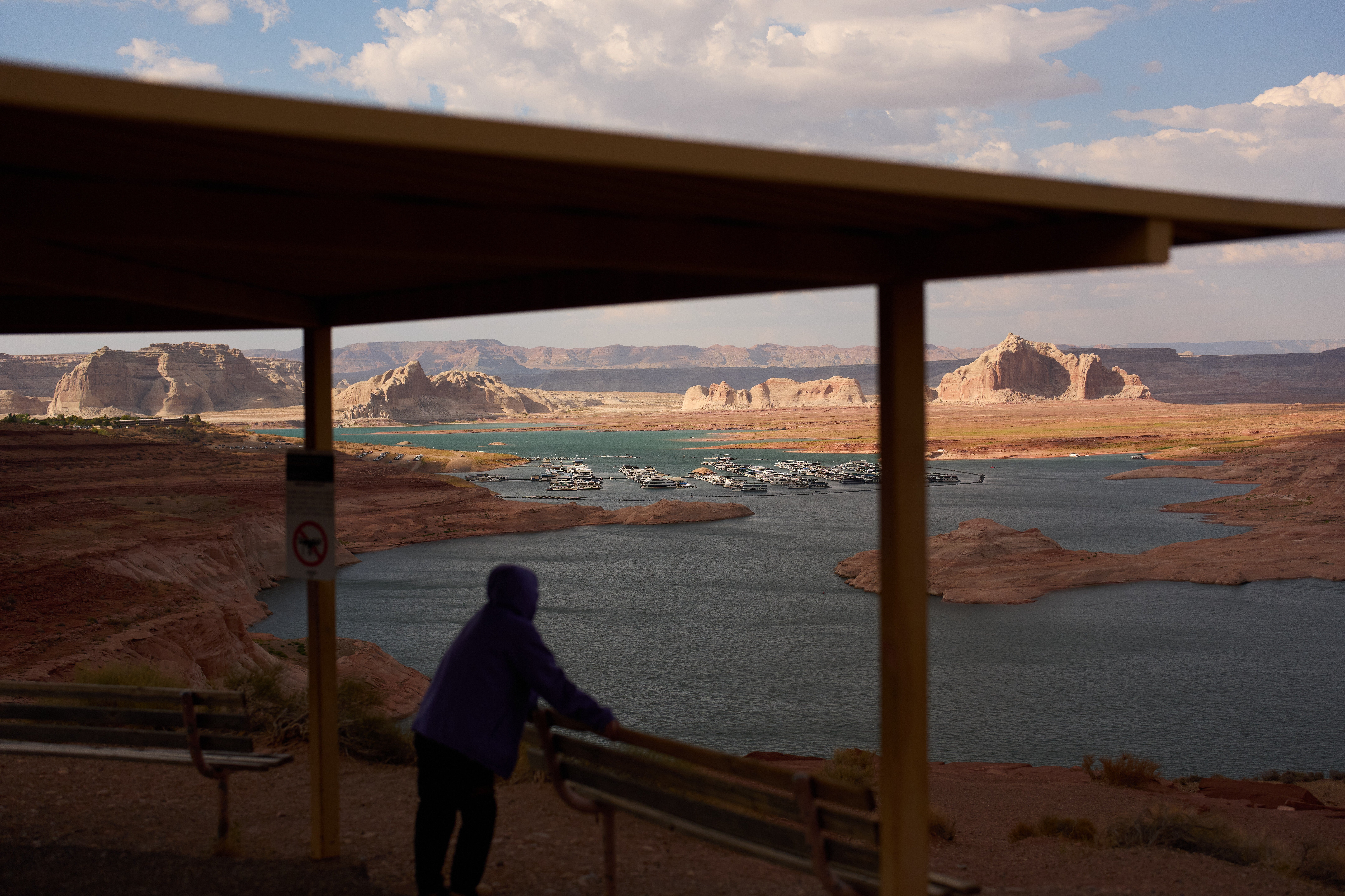 A person stands at an overlook near the Wahweap Marina on Lake Powell at the Glen Canyon National Recreation Area