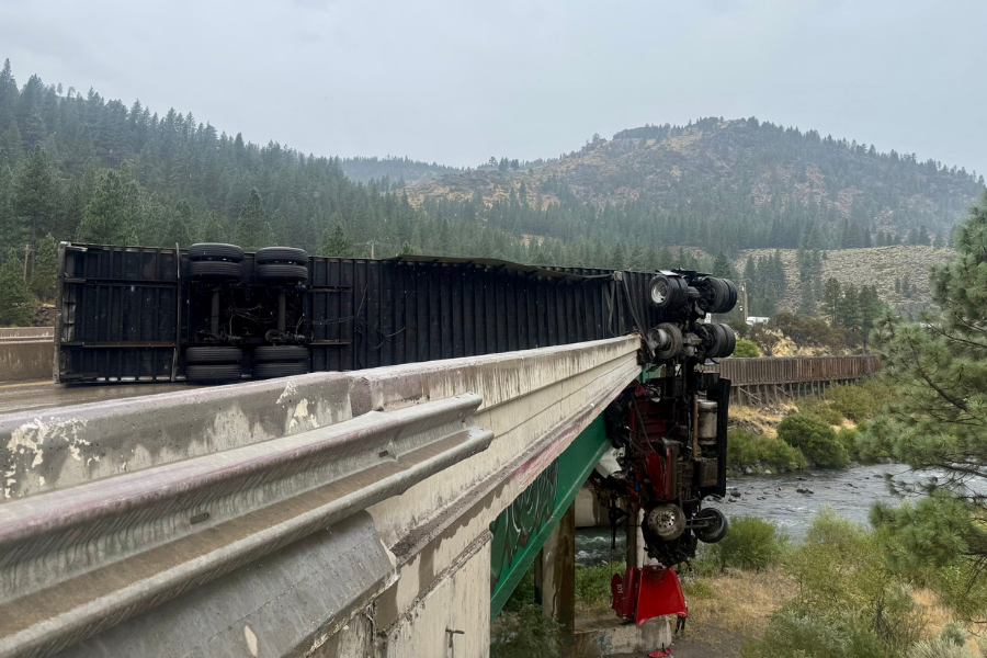 A tractor-trailer truck crashed through an I-80 railing near Truckee, California on August 28, leaving its cab dangling 80 feet above a bridge