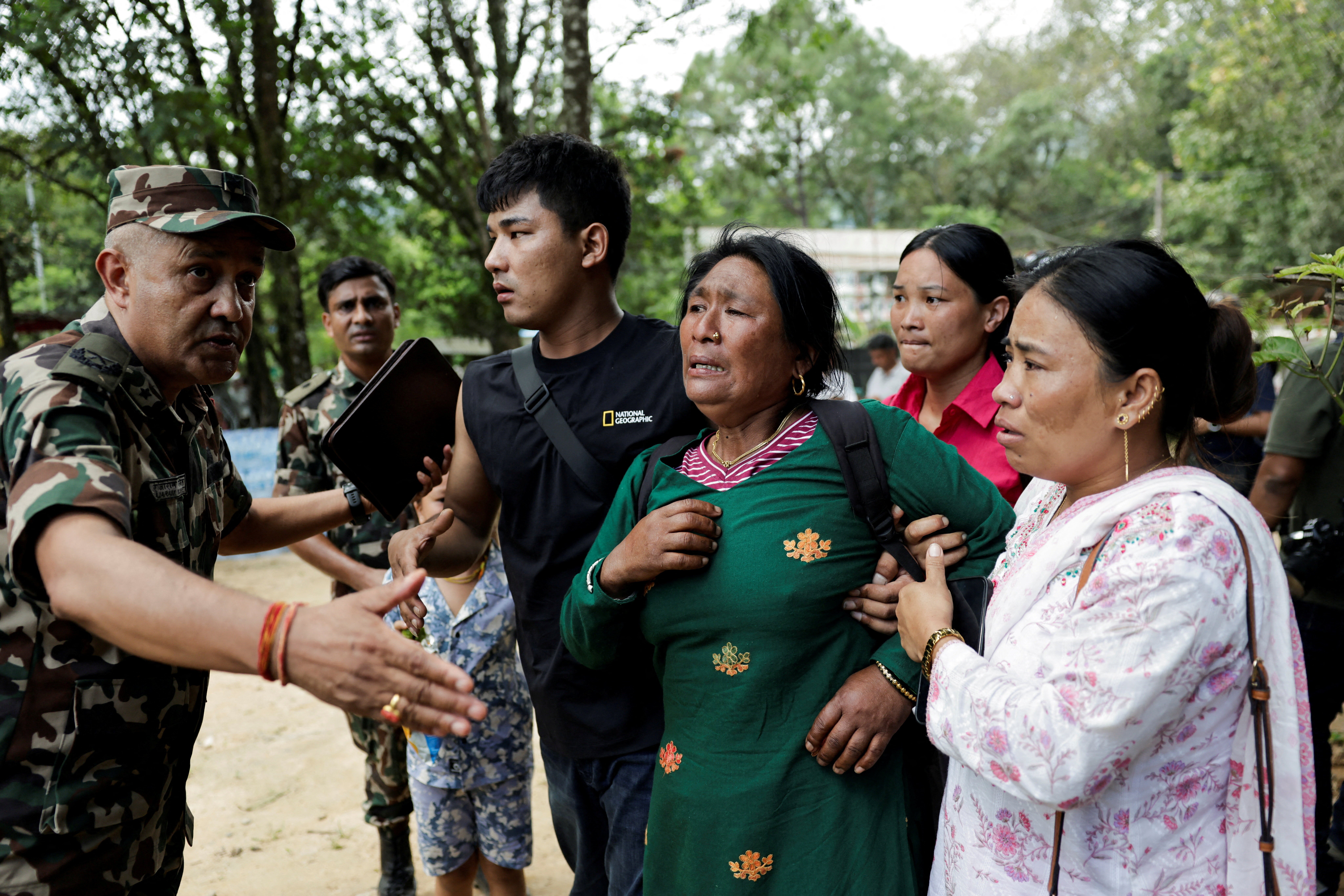 A woman is consoled as she arrives at Maithili Barrack, an army training centre which serves as a primary base to airlift survivors from Rasuwa district, following flash floods and a mudslide, in Trishuli, Nuwakot district, Nepal, August 28, 2026.
