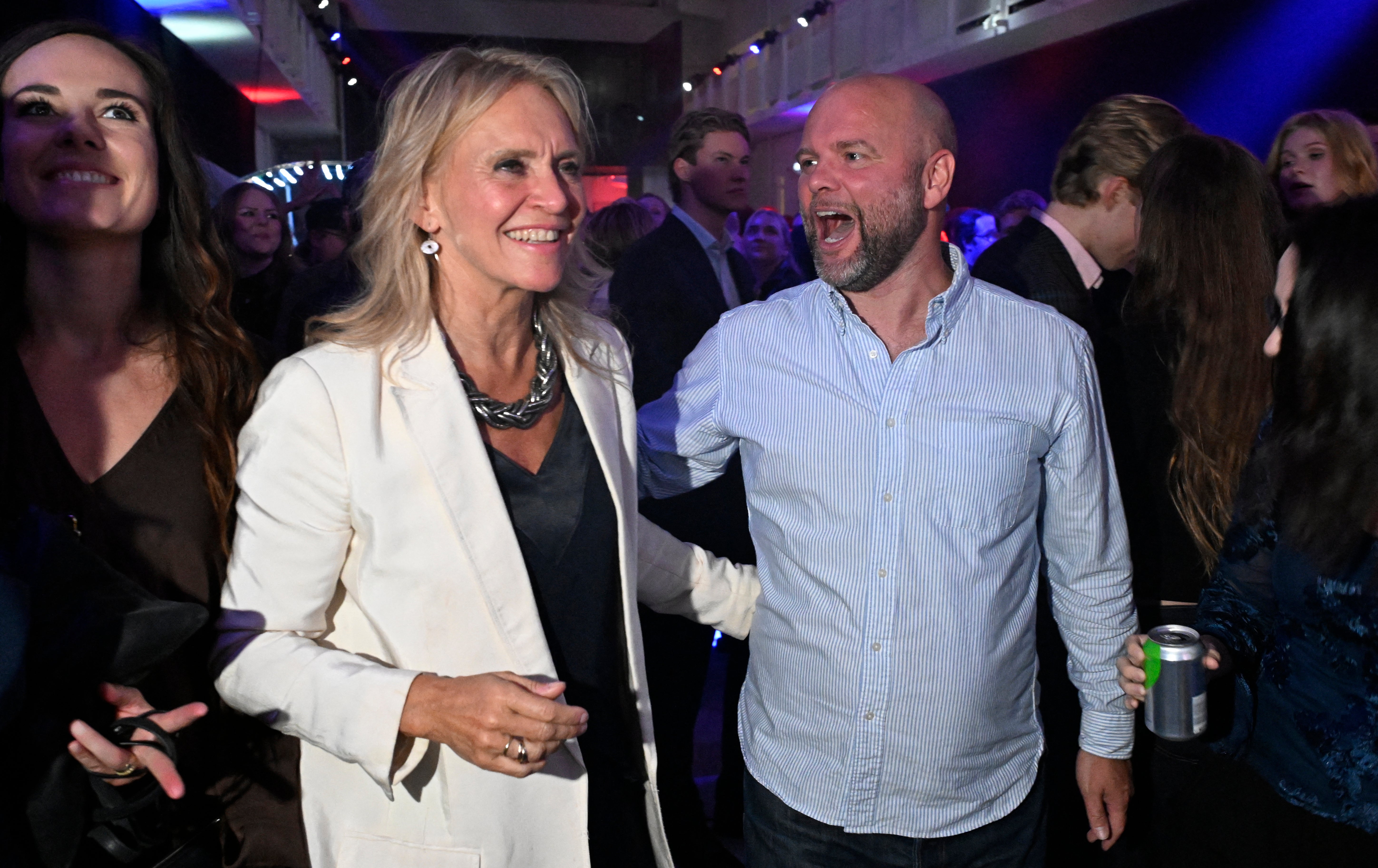 Iceland's Foreign Minister Thorgerdur Katrin Gunnarsdottir (L) reacts alongside a supporter as early results are announced during the 'Yes' campaign's referendum night event in Reykjavik, Iceland, on August 30, 2026