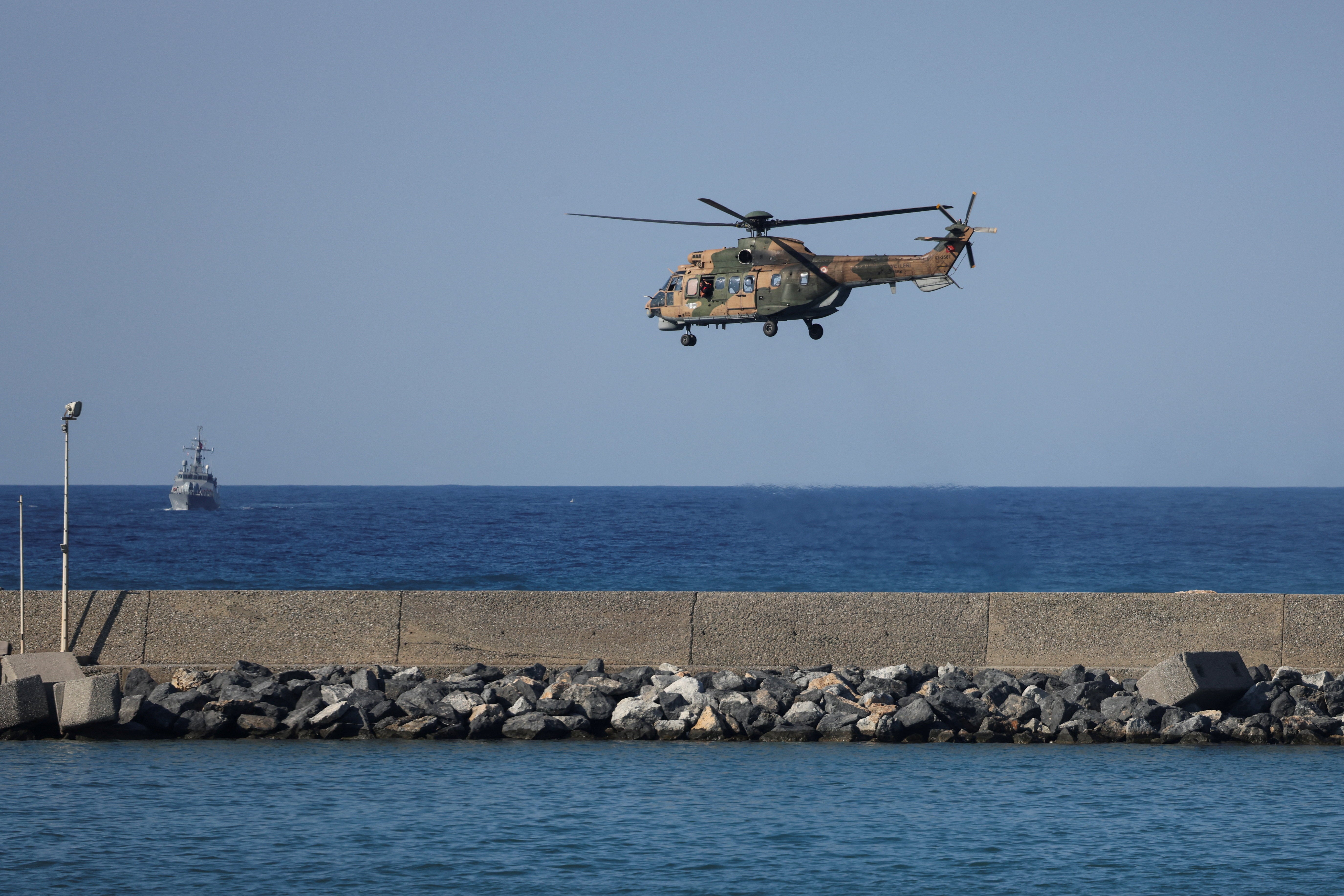 A helicopter flies near the area where a passenger boat capsized off the coast of Kyrenia in Turkish-controlled northern Cyprus, August 30, 2026. (Reuters)