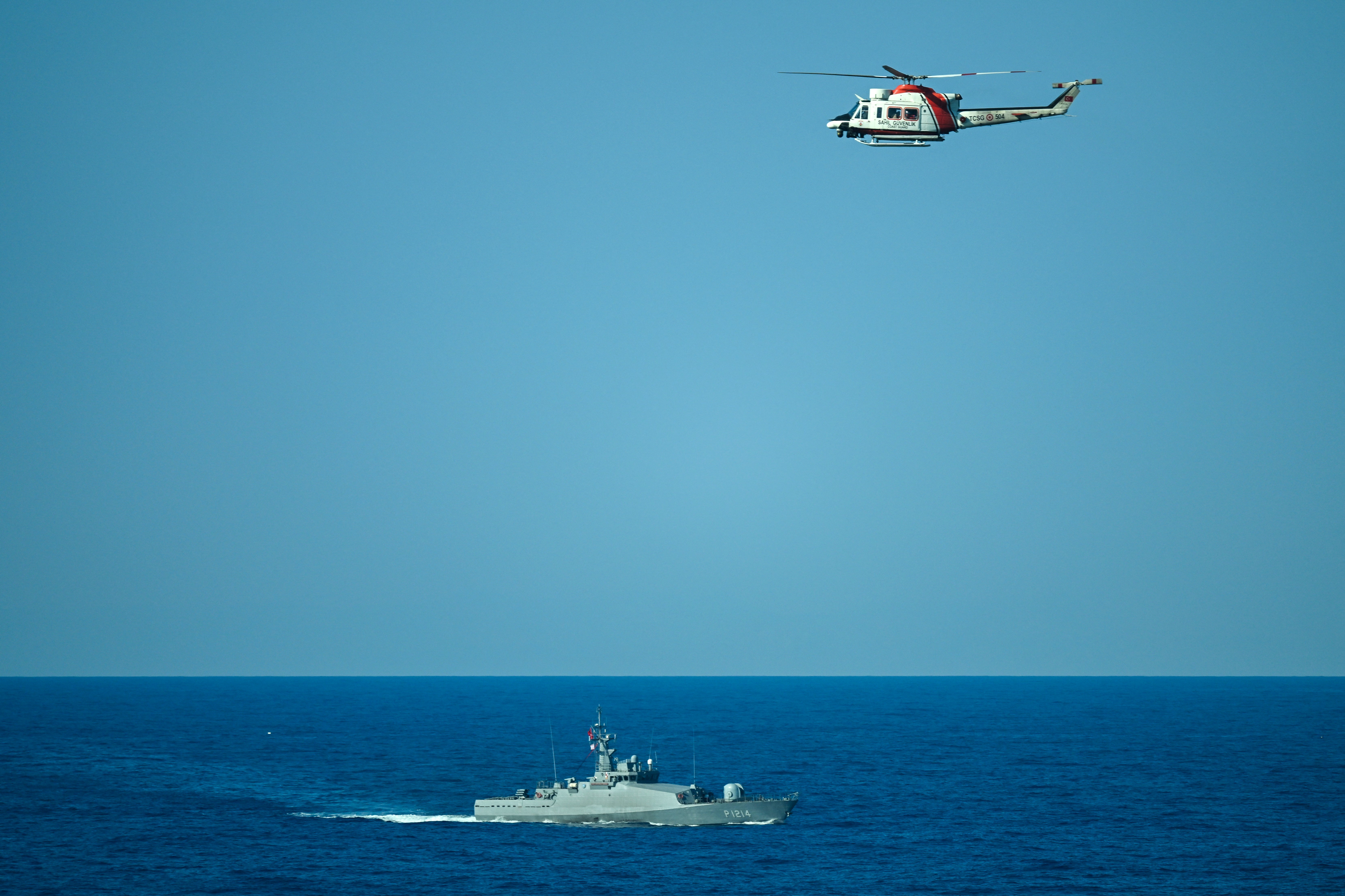 Turkish naval ship P-1214, a Tuzla-class patrol boat, and a helicopter search the waters during a rescue operation off the coast of Kyrenia, in the self-proclaimed Turkish Republic of Northern Cyprus (TRNC), recognised only by Turkey, on August 30, 2026, after a ferry capsized. (AFP/Getty)