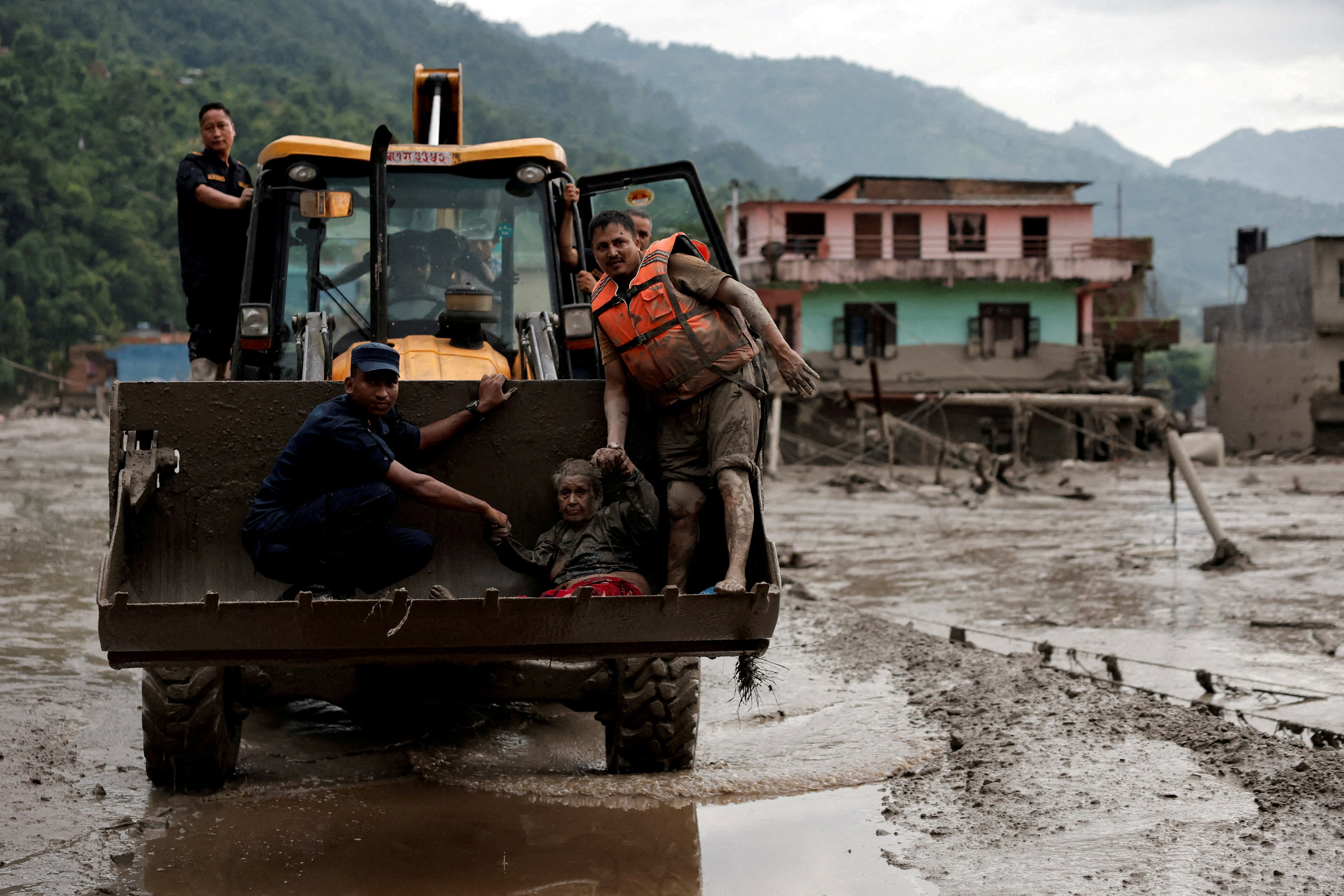 A survivor is transported to a safer place in heavy machinery following a flash flood at Trishuli in Nuwakot district, Nepal, August 26, 2026.