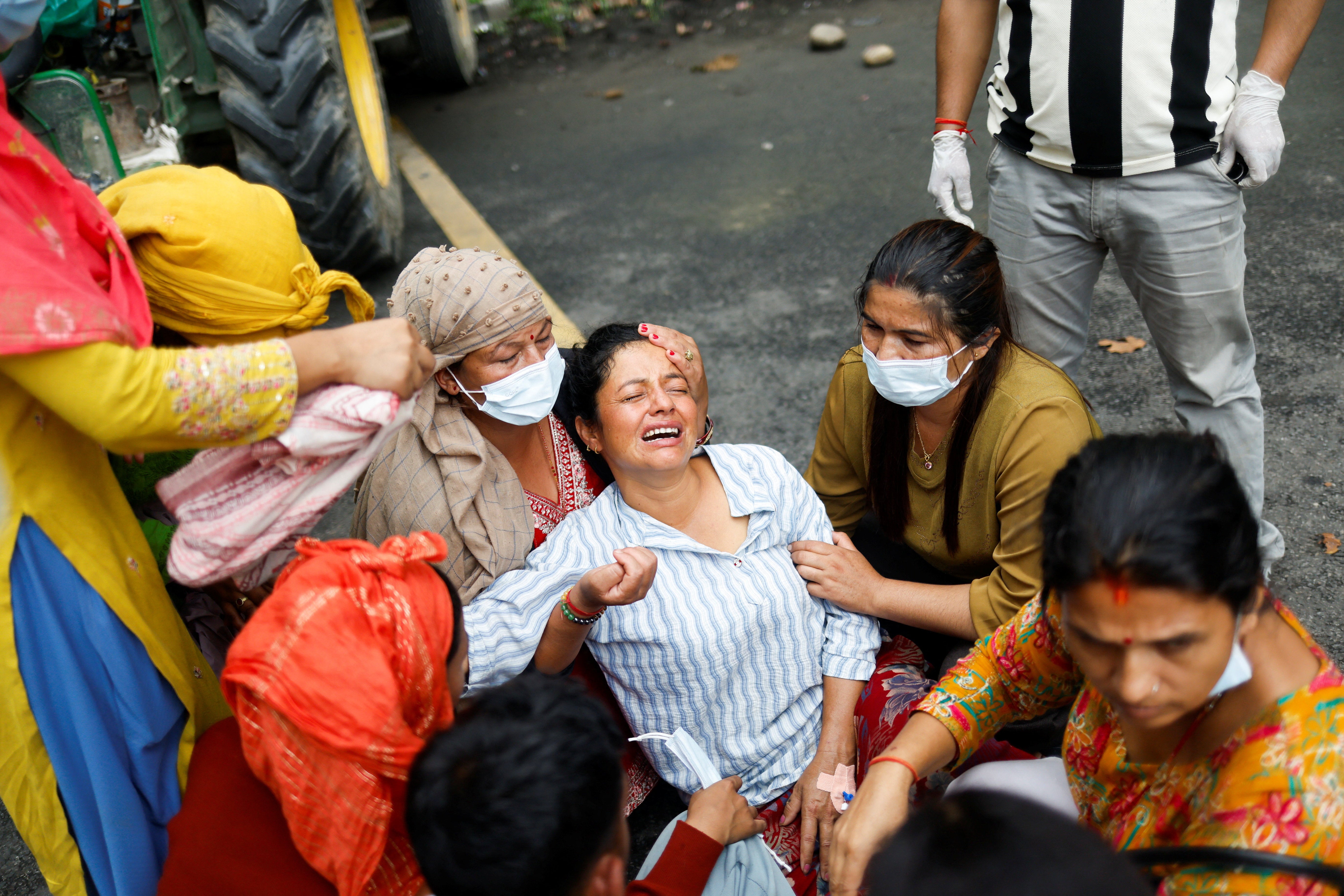 Muna Khadka, mother of Aayush Khadka, 21, who lost his life during the deadly flash floods mourns outside a cremation ground in Chitwan, Nepal