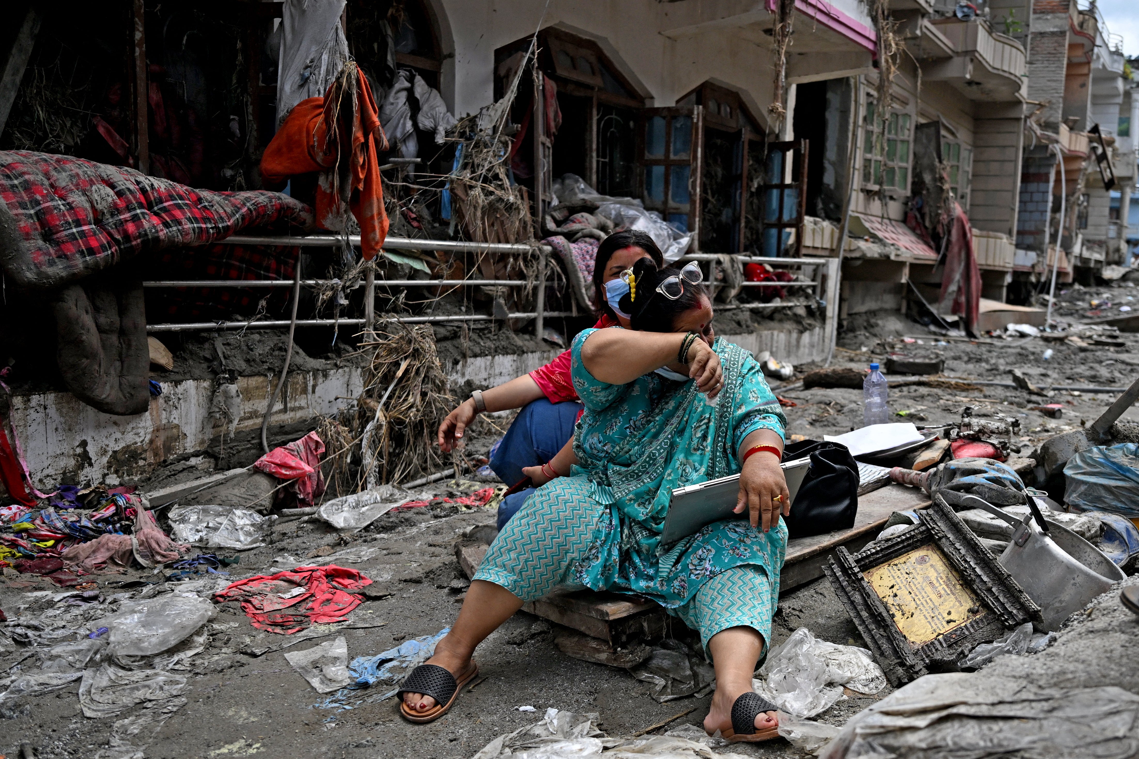 People salvage belongings following flash floods in Devighat