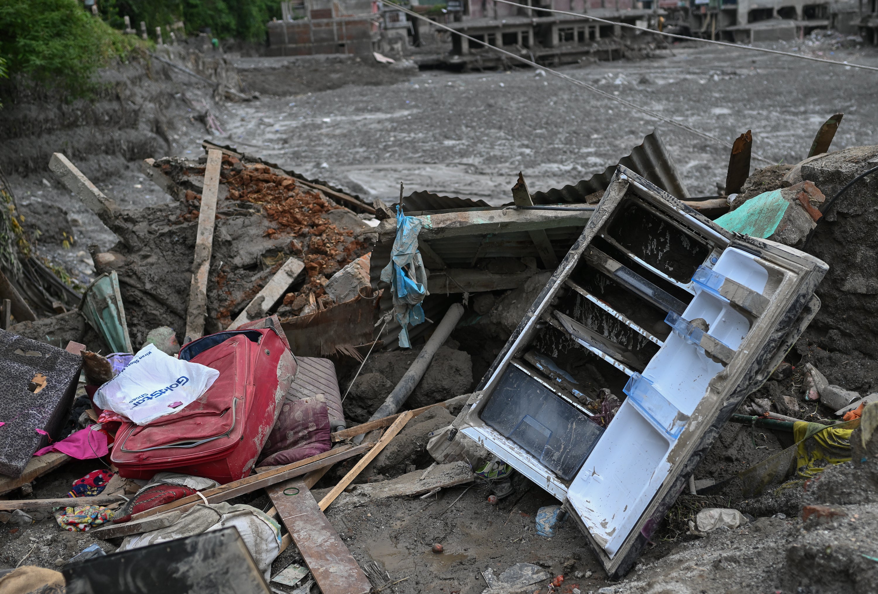 Household belongings lie scattered in mud