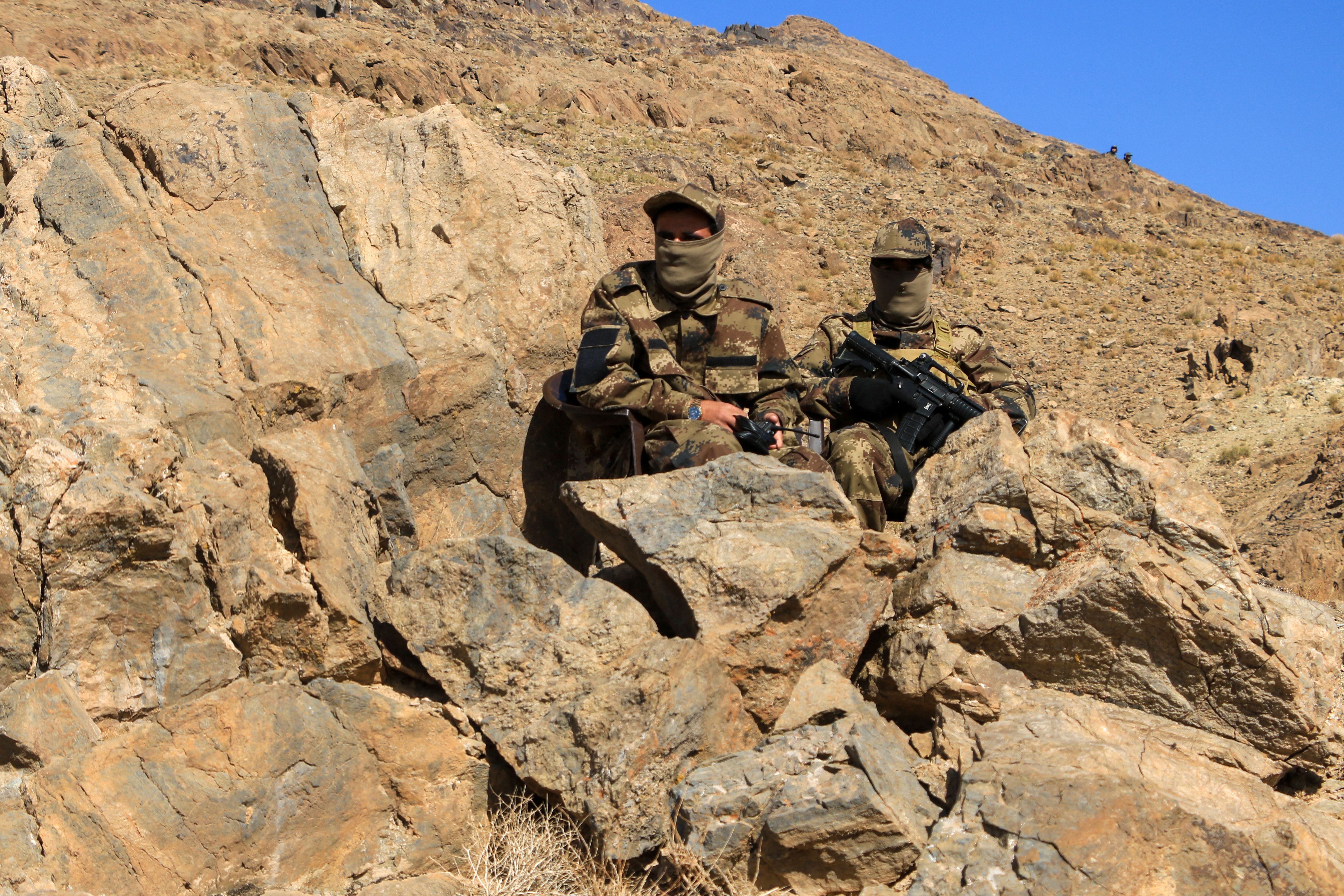 Afghan security personnel sit guard at the inauguration ceremony of an iron ore mine, at Ghorian district in Herat province