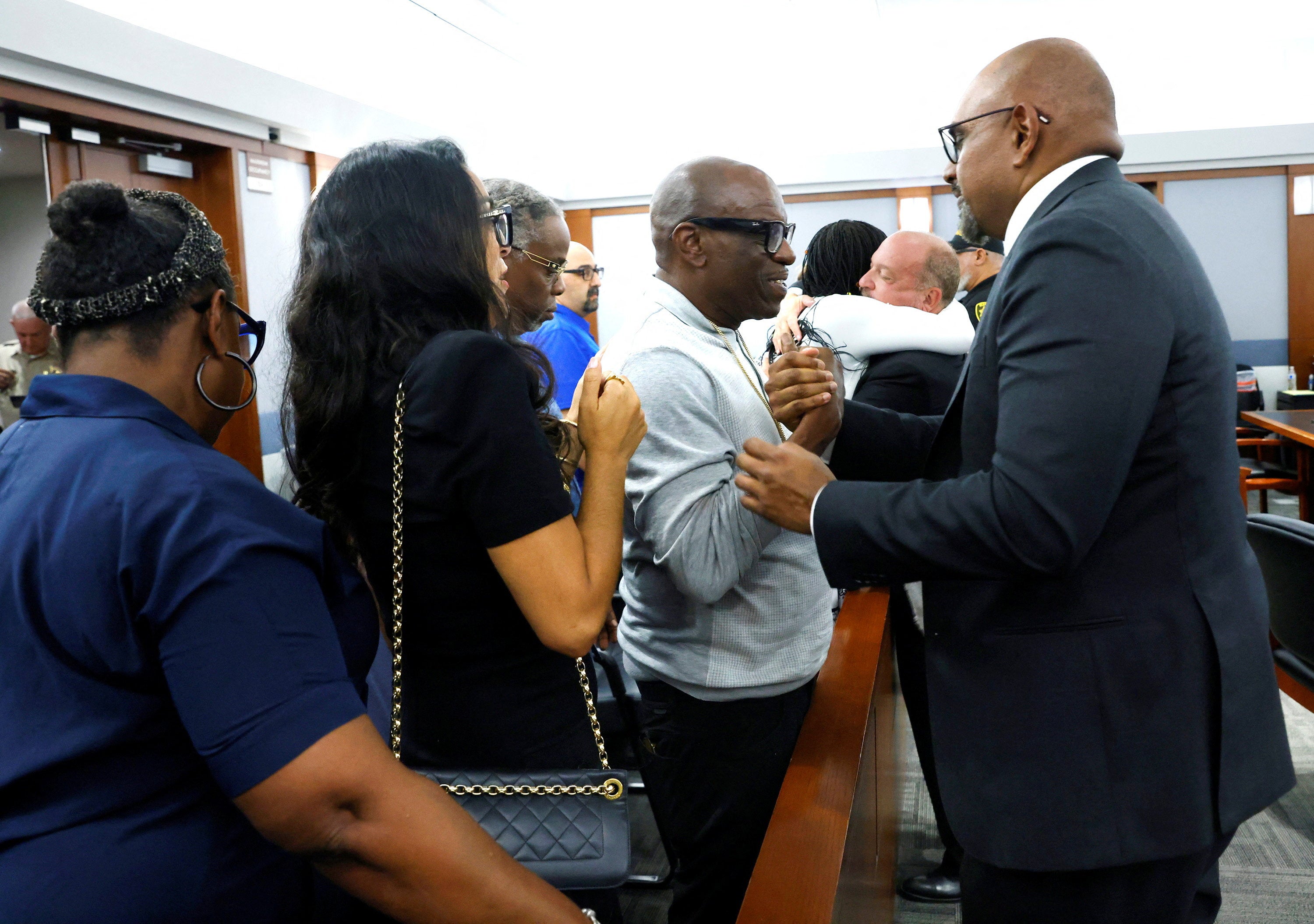 Friends and family members of rapper Tupac Shakur line up to thank Chief Deputy District Attorneys Binu Palal, right, and Marc DiGiacomo (Reuters)
