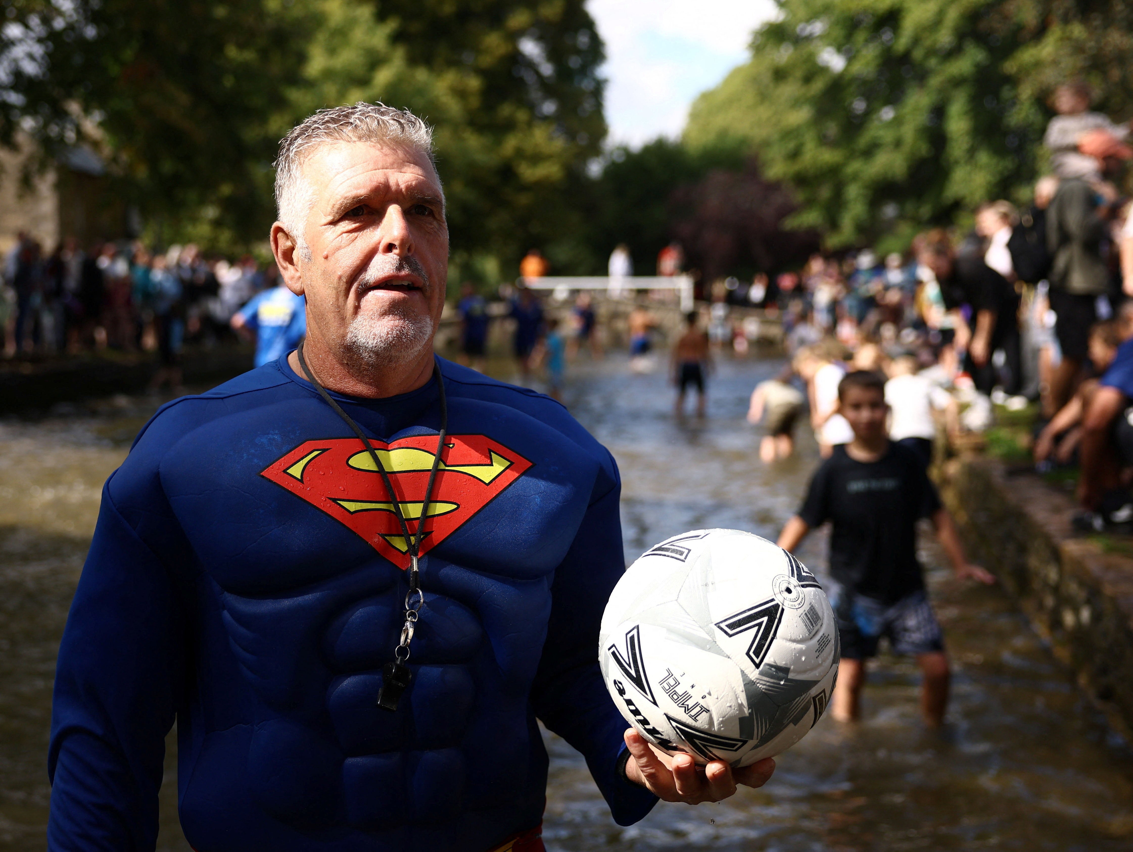 The referee wears a Superman costume during the annual football match in the River Windrush in Bourton-on-the-Water