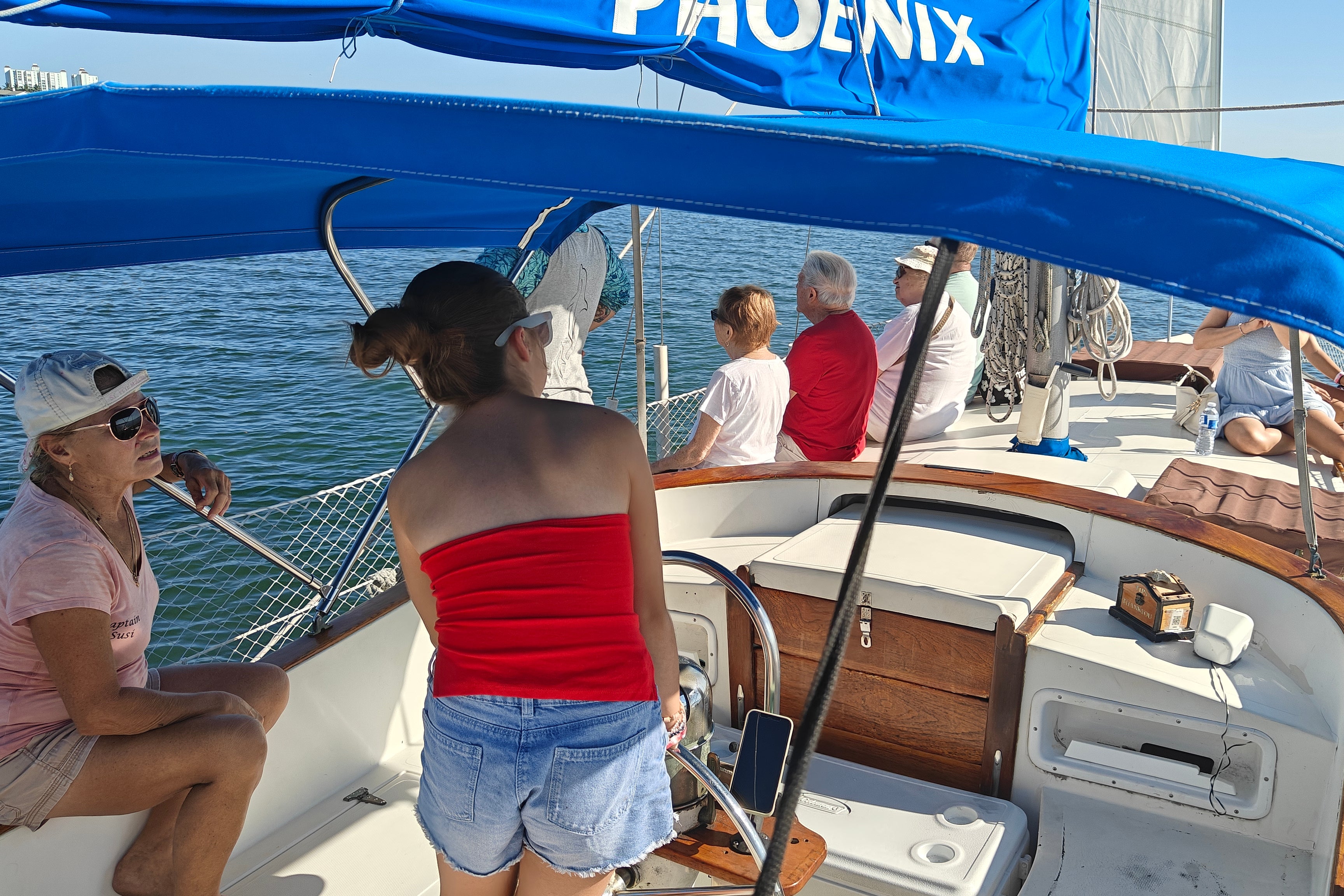 Amelie takes the helm of our boat on the search for dolphins under the eye of captain Susi (Marc Shoffman)