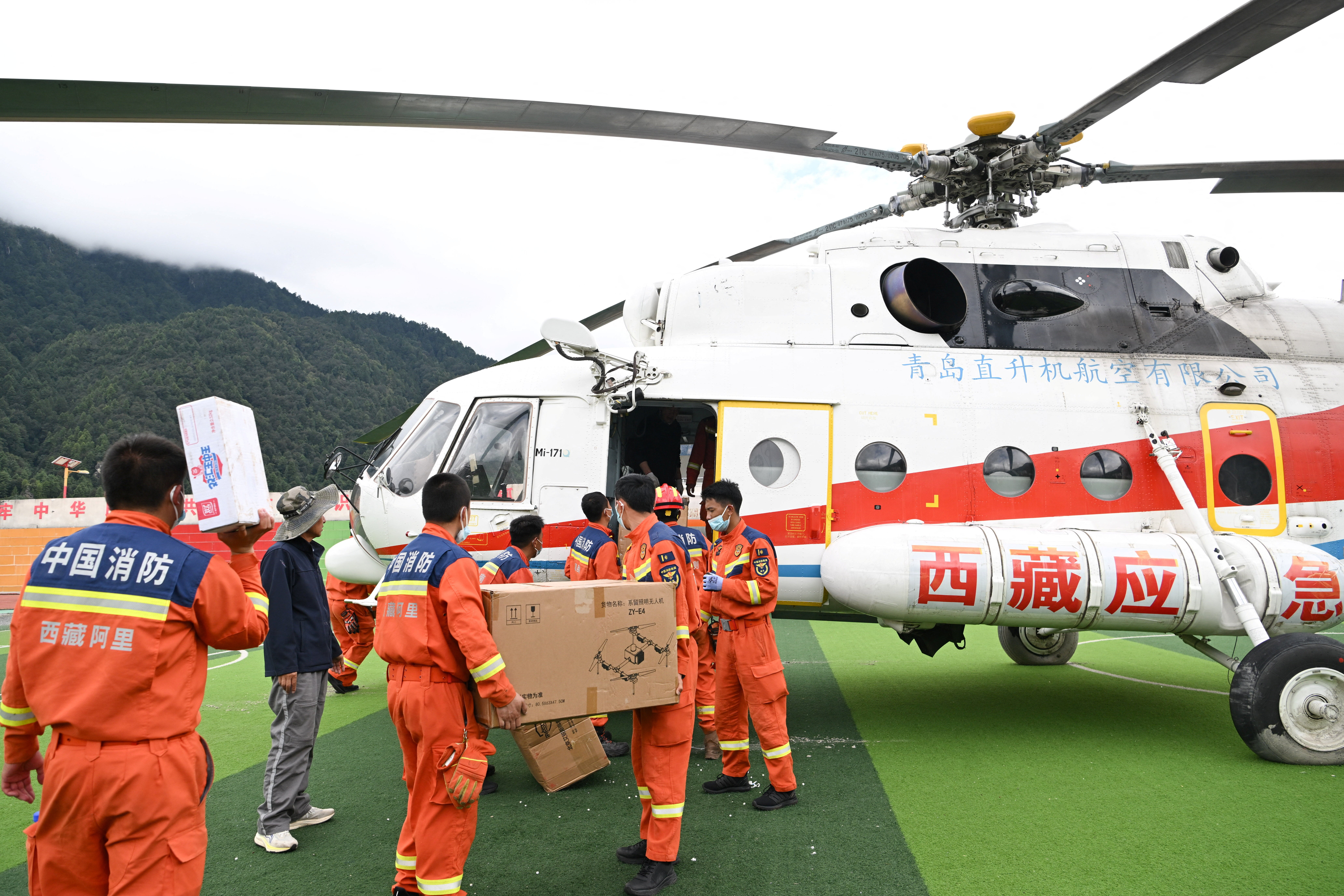 Firefighters deliver emergency supplies by helicopter following a mudslide in Gyirong county, Shigatse, Tibet Autonomous Region (Reuters)