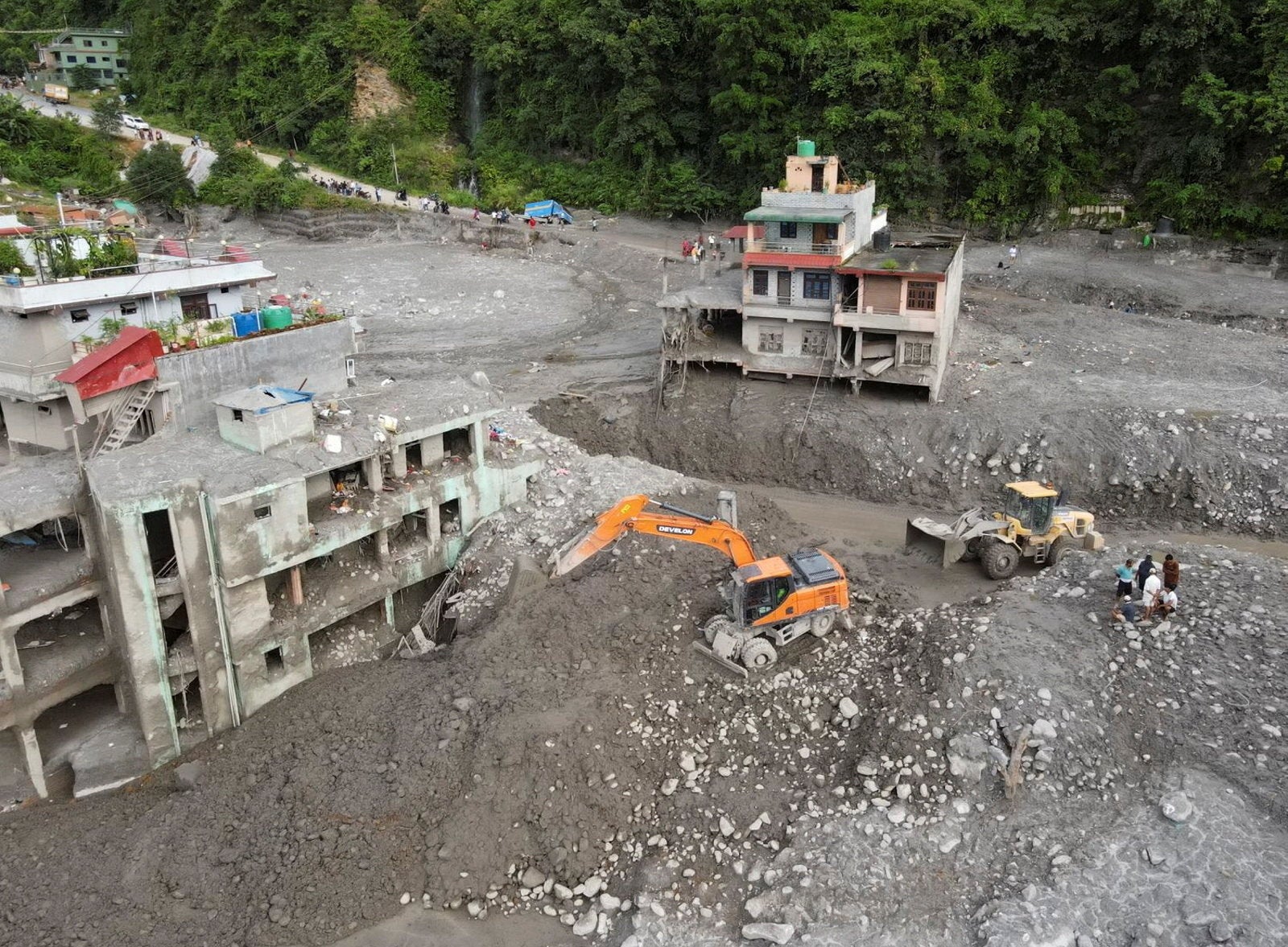 A drone view of excavators clearing mud to make way for a road after flash floods and a mudslide, in Trishuli, Nuwakot district, Nepal
