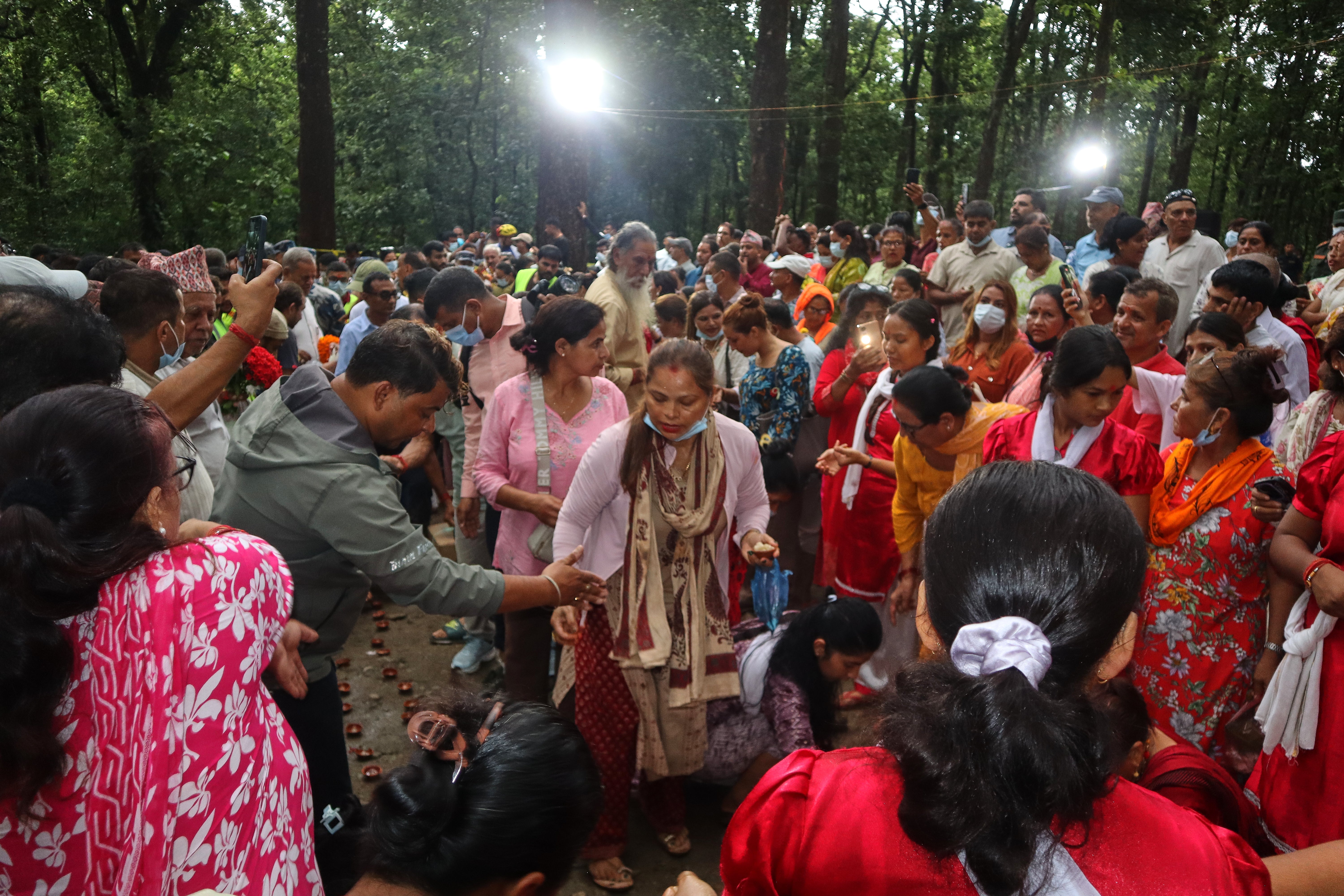 People gathered to light candles and pray for the victims of flash floods at the site of a mass burial in Chitwan, Nepal (AP) (AP)
