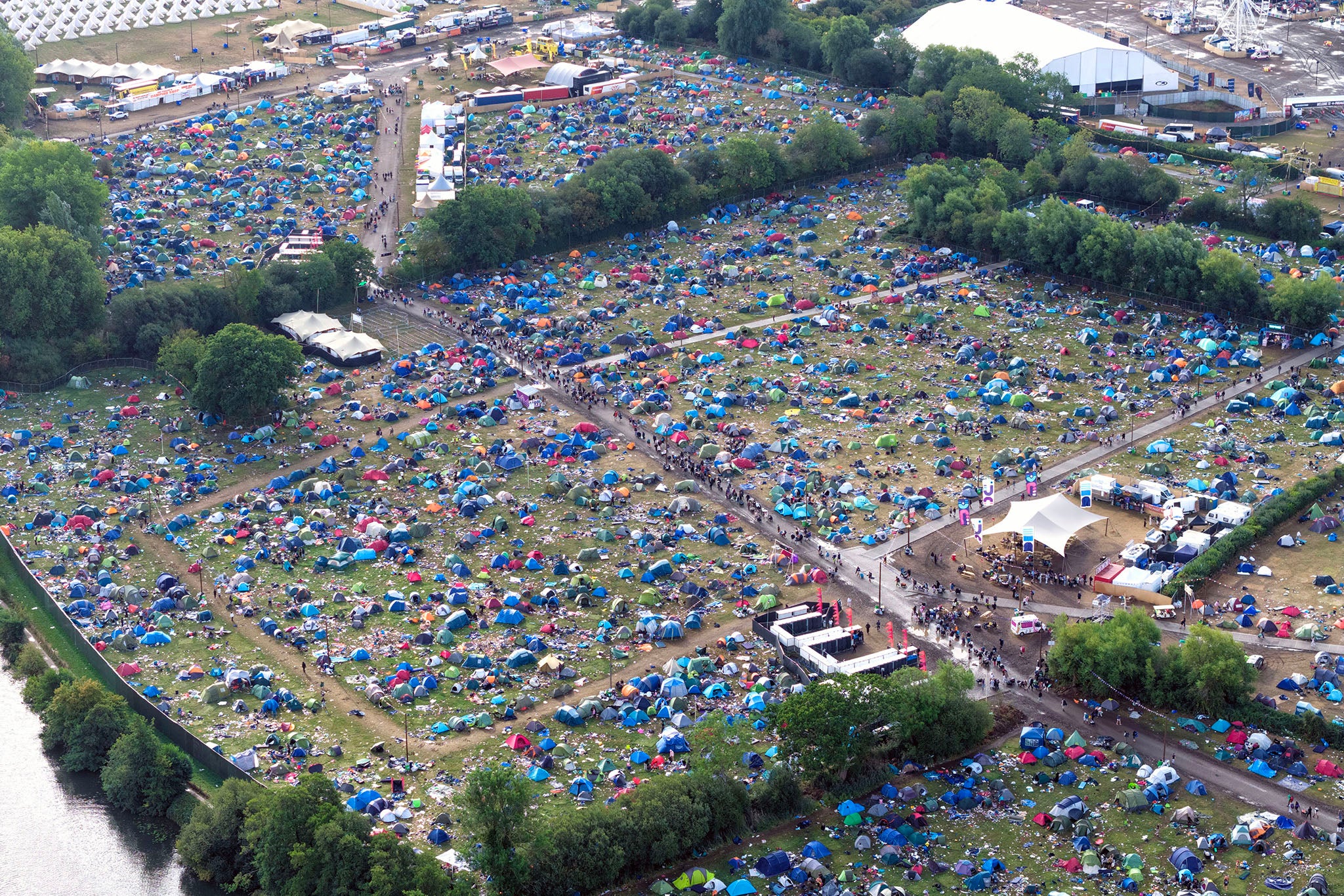 Broken tents, sleeping bags, and blow-up mattresses can be seen in drone footage