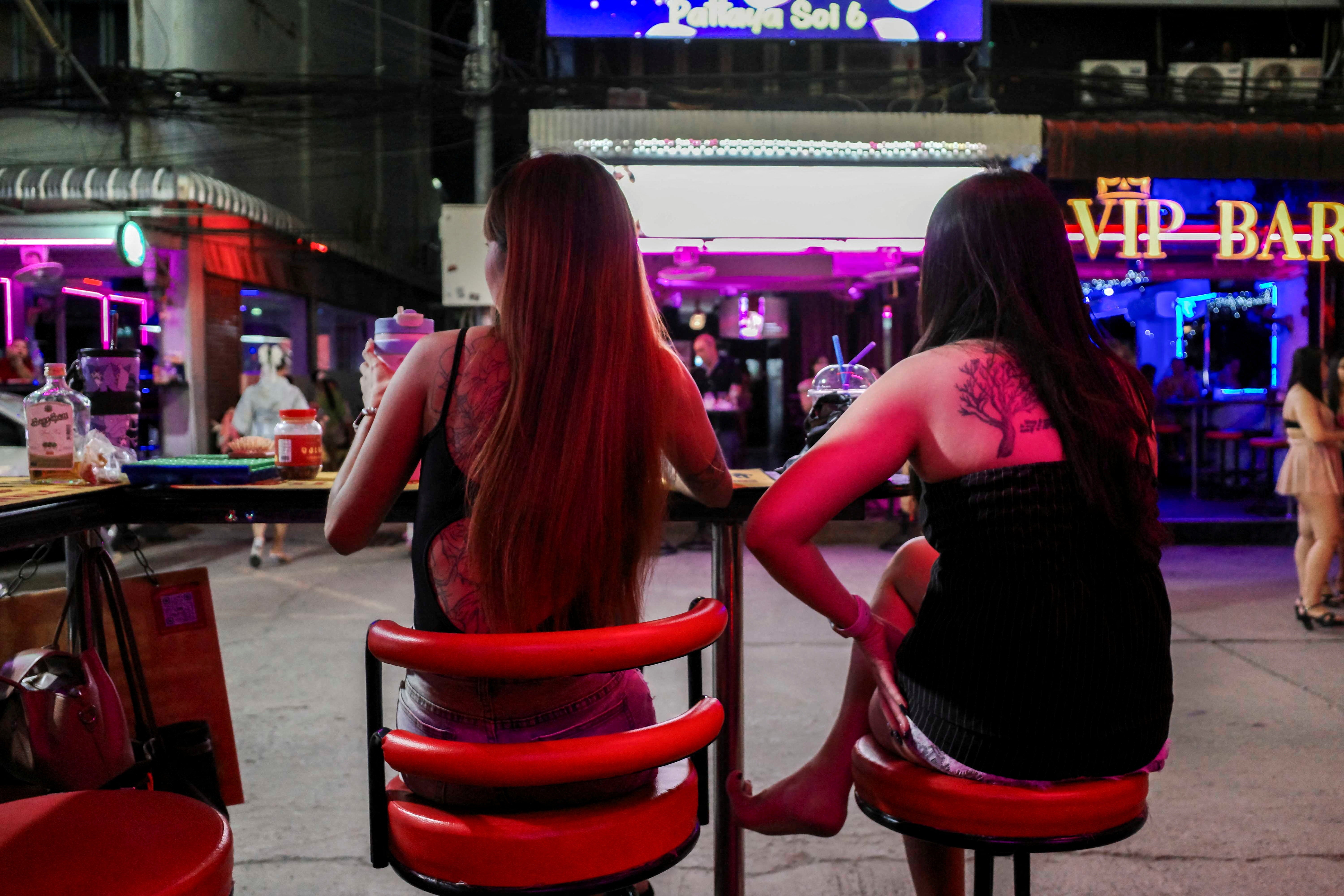 People wait at a bar along a street lined with bars and entertainment venues, in Pattaya City, Thailand, September 1, 2026. REUTERS/Chalinee Thirasupa