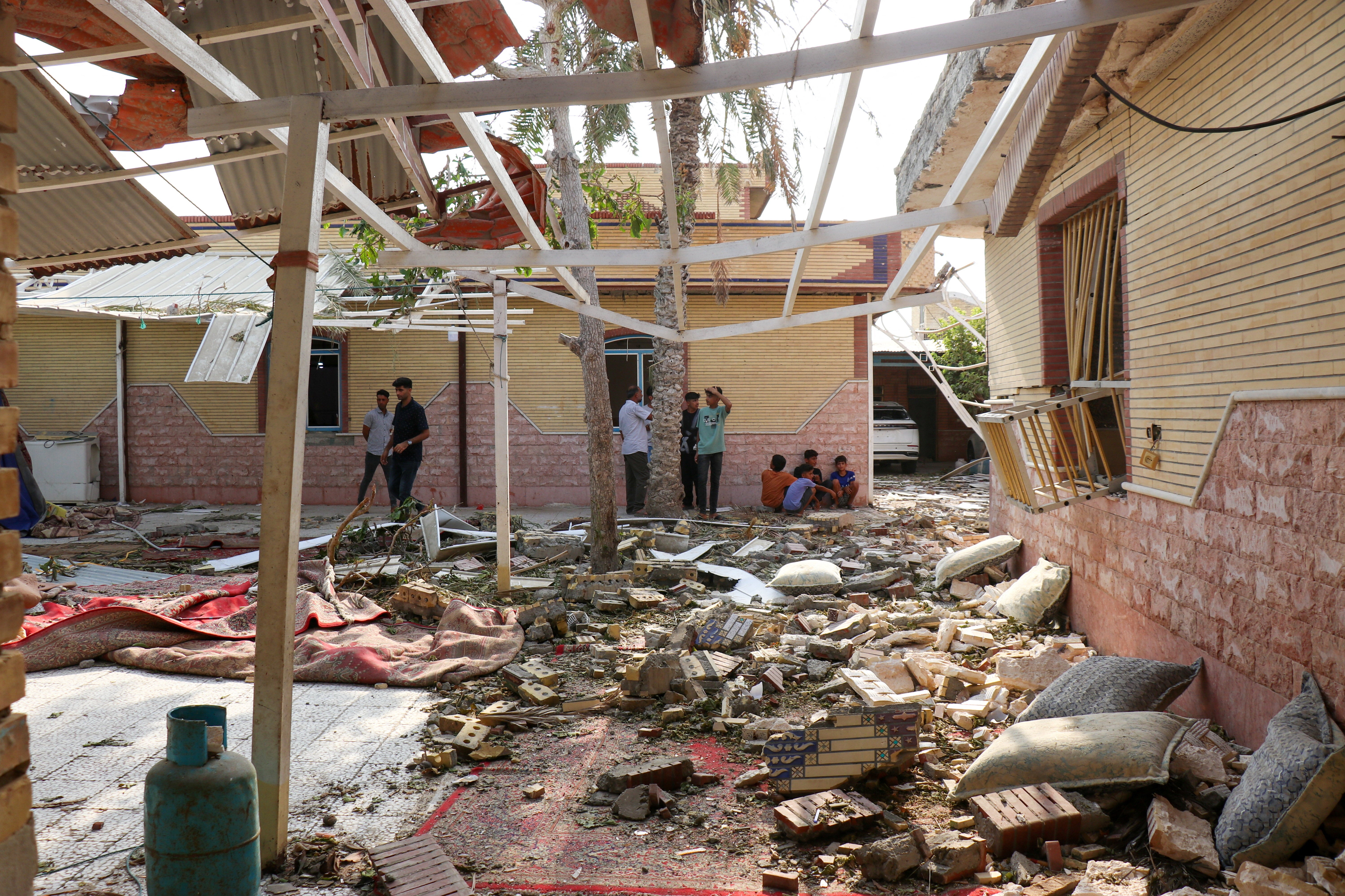 Rubble lies around damaged houses following a reported attack near a wedding gathering in Kuhistik (Reuters)