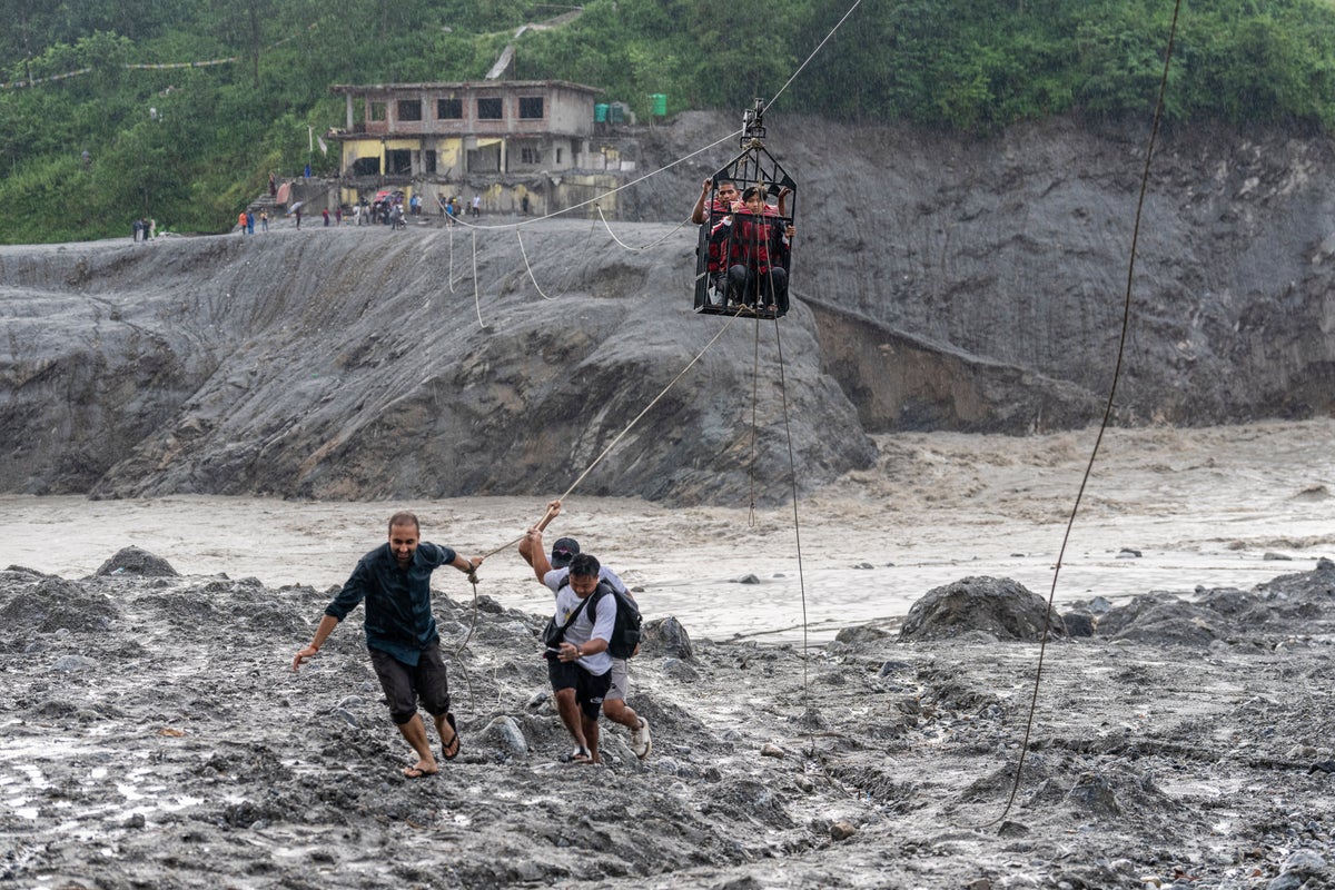 Nepal flood survivors in relief camps trade supplies for medicine and cross rivers by zip line