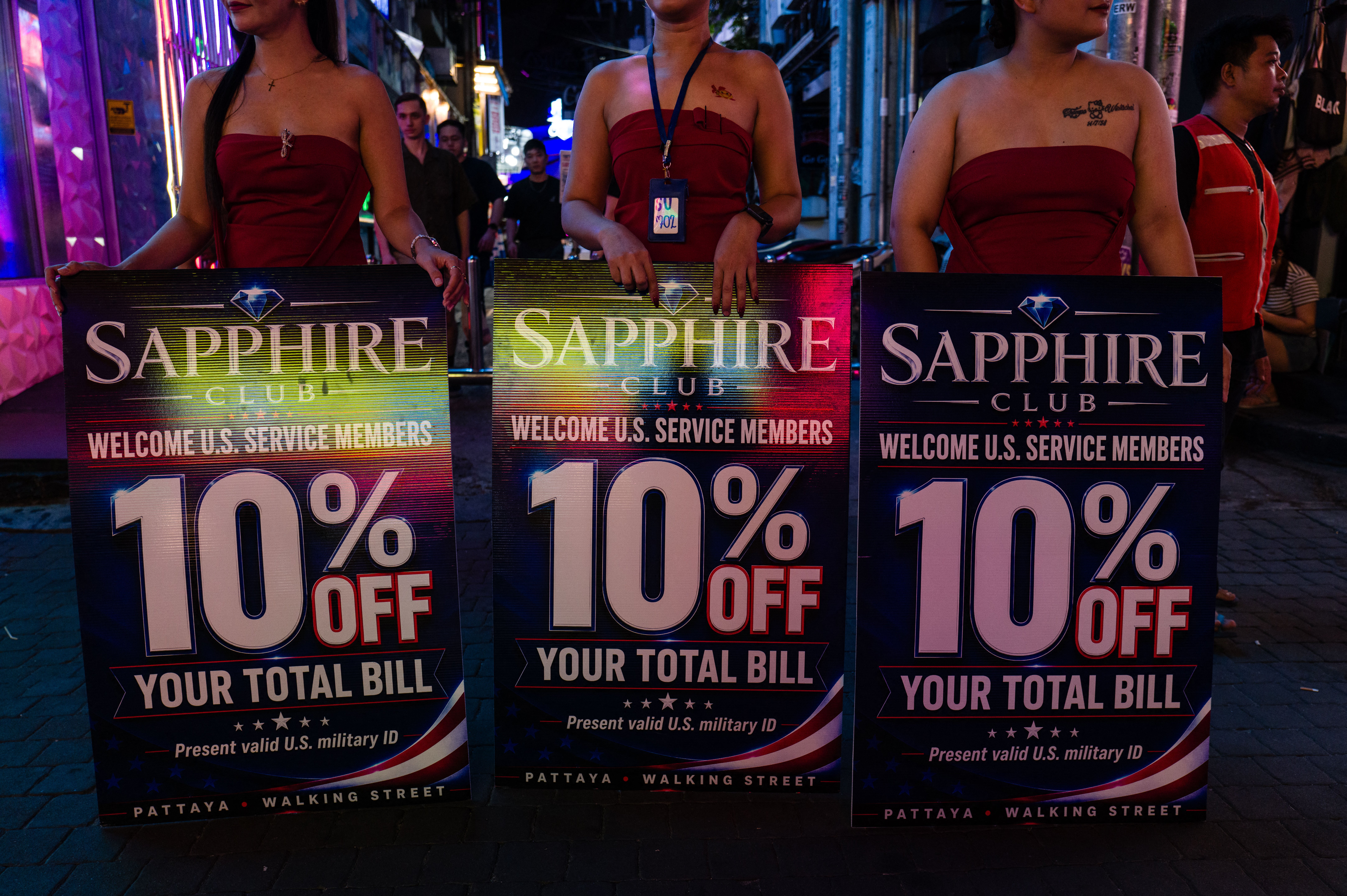 Hostesses advertise discounts to US service members of the nuclear-powered aircraft carrier USS Abraham Lincoln (CVN-72) at Walk Street in Pattaya on September 2, 2026