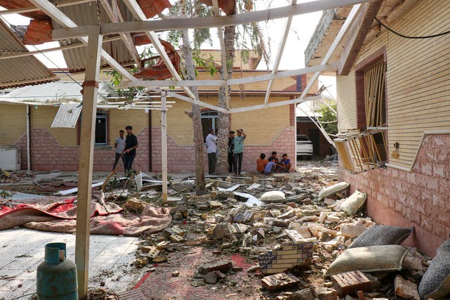 <p>Los escombros se amontonan alrededor de las casas dañadas tras un presunto ataque ocurrido cerca de una celebración nupcial en Kuhistik, Sirik, Irán</p>