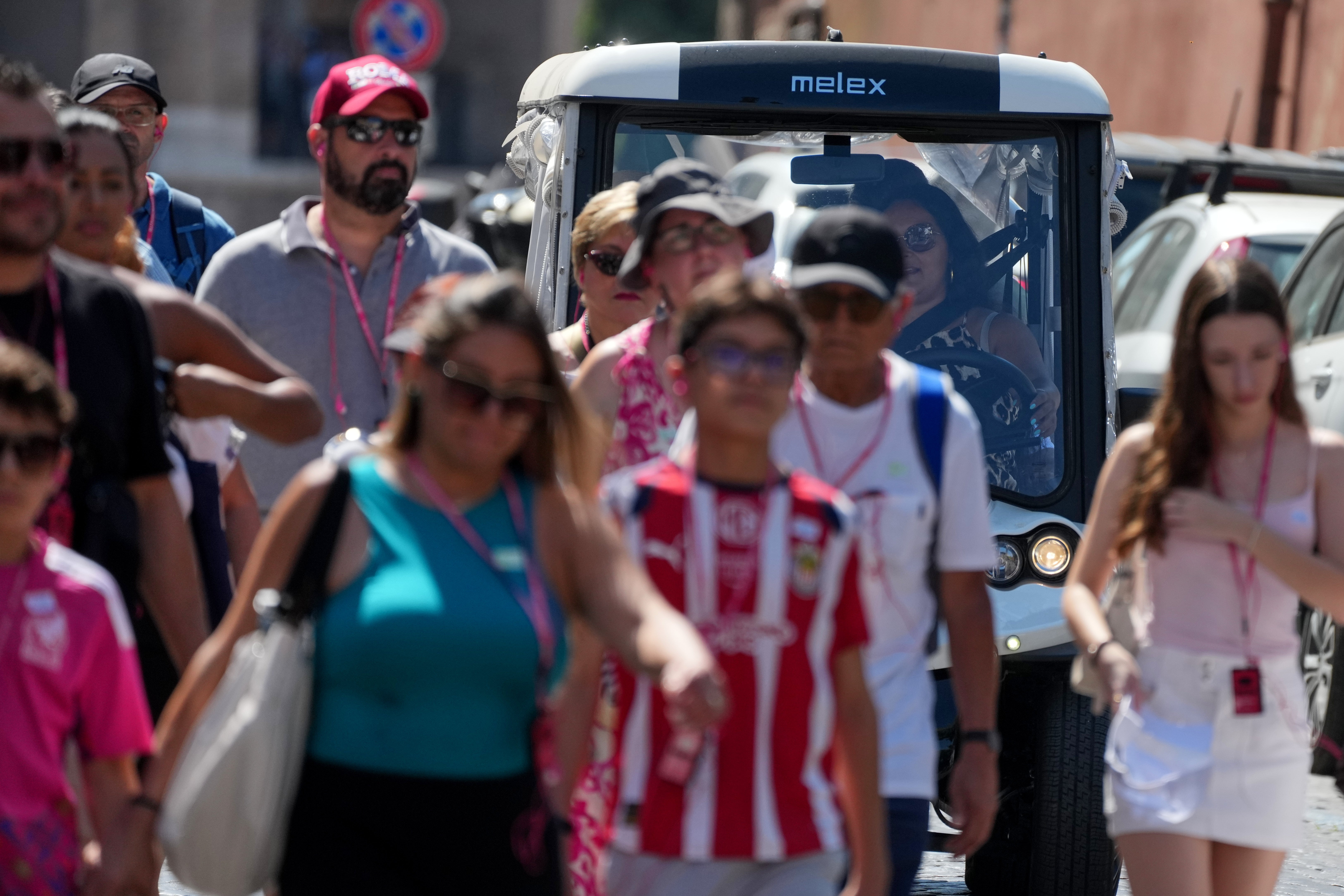 A golf cart makes its way through crowds of tourists in Rome’s historic center, Tuesday, Aug. 18, 2026 (AP Photo/Gregorio Borgia)