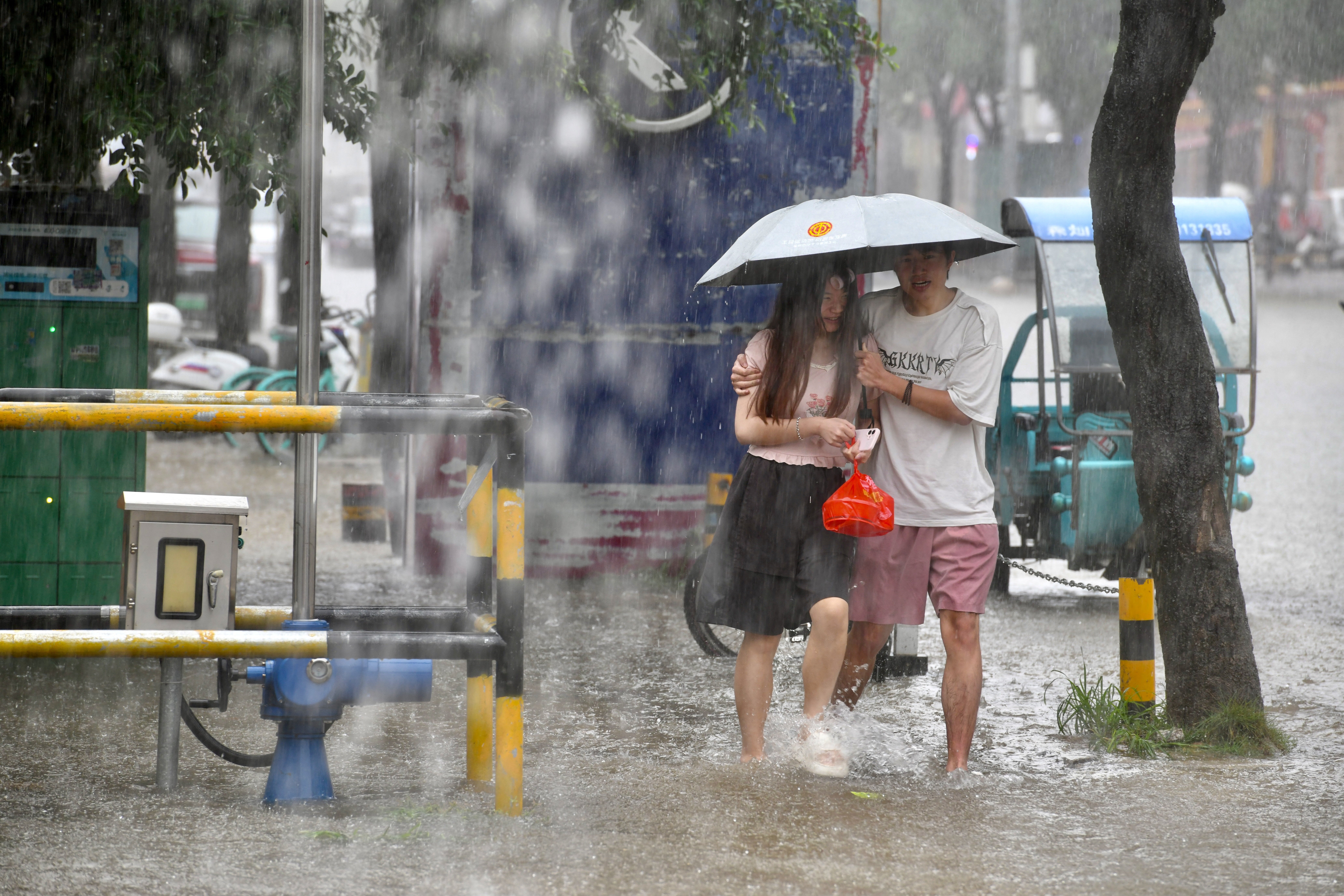Residents walk along a flooded street amid heavy rain in Fuzhou, Fujian province, China, on 3 September 2026