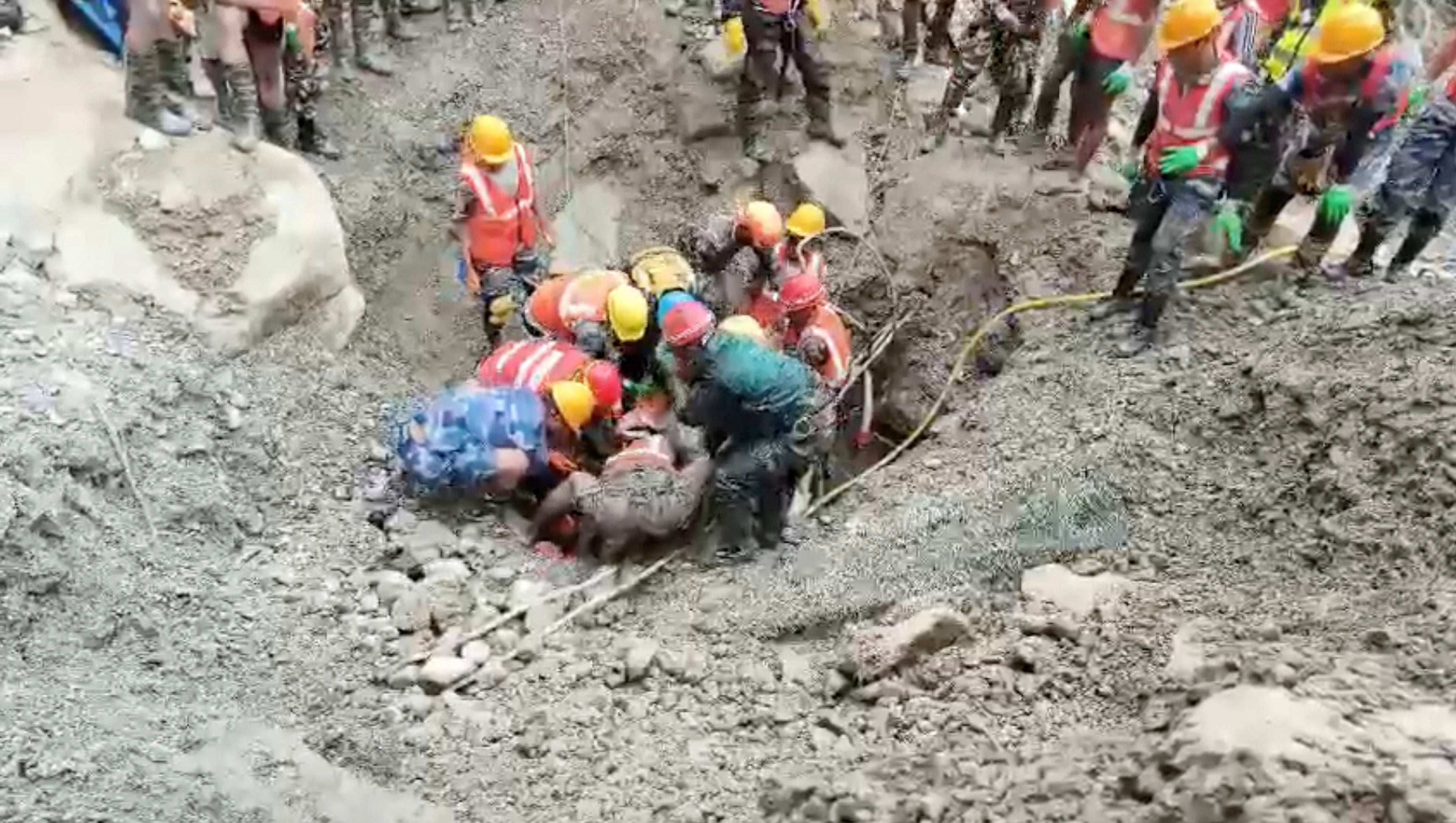 Rescuers work to pull out a survivor from a tunnel linked to a hydropower station following deadly flash floods and mudslides, at a location given as Rasuwa district, Nepal