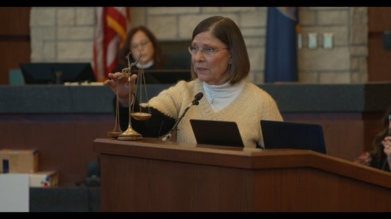 Dana Chandler uses the scales of justice while delivering closing arguments on March 7, 2025, to defend herself at her third double-murder trial in the 2002 slayings of her ex-husband Mike Sisco and his girlfriend, Karen Harkness