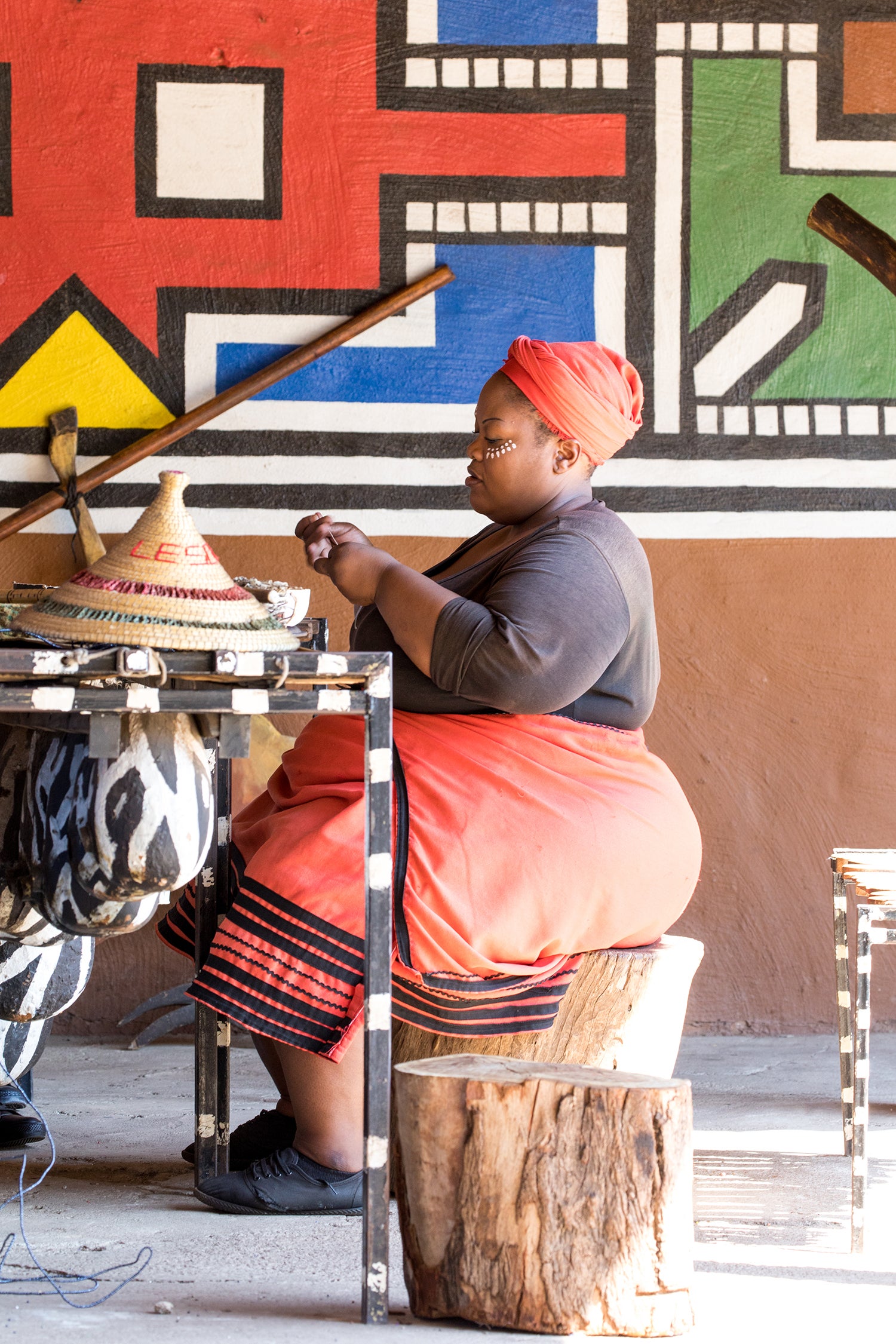 A craftswoman at Lesedi Cultural Village in South Africa uses traditional hand skills, an example of the knowledge and livelihoods Safia Minney believes fashion’s just transition must value and protect