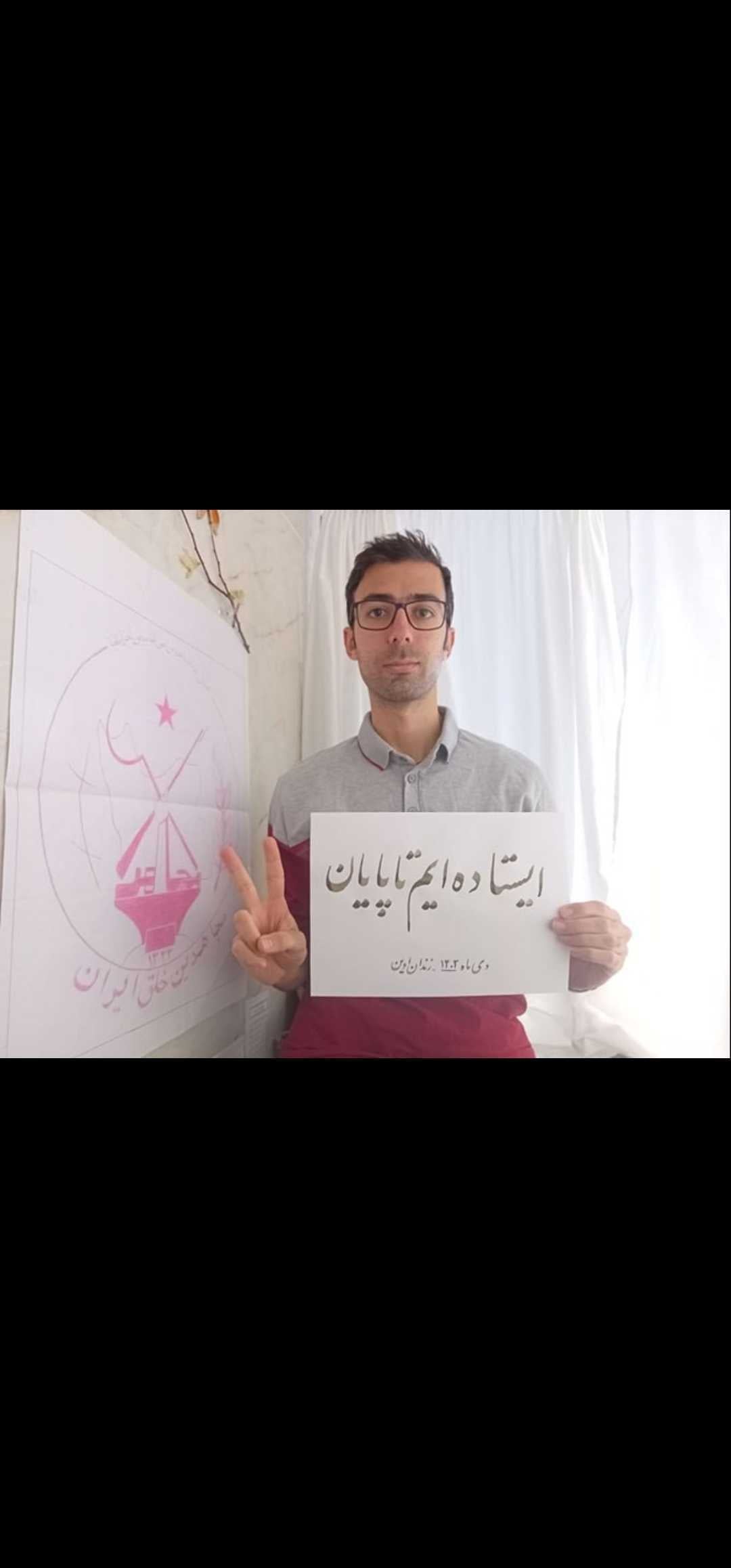 Another image of Hamed Baniamerian from inside prison, holding a sign with a similar message: 'We will stand until the very end'