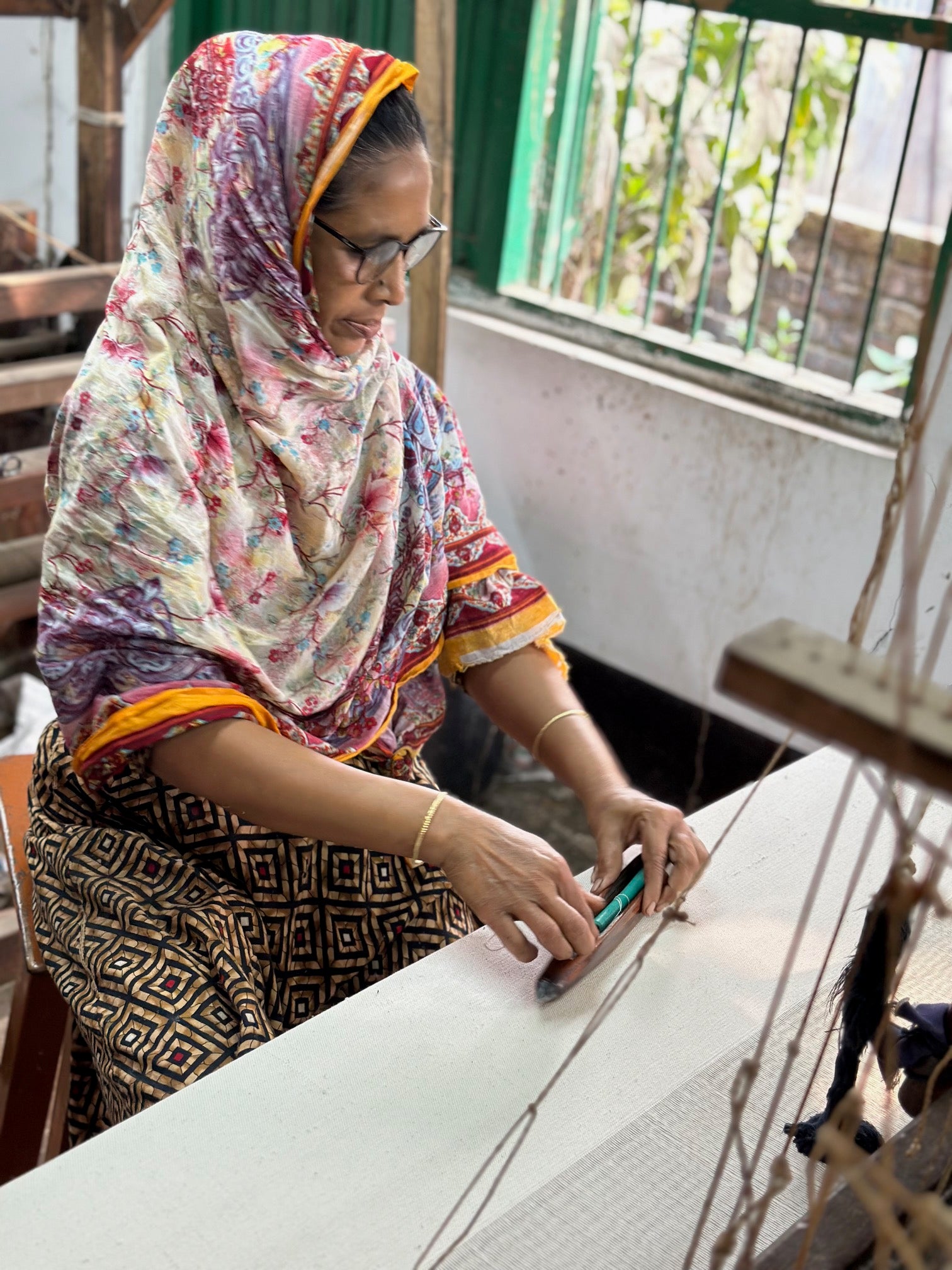 A weaver at Swallows in Bangladesh creates fabric for Indilisi, preserving traditional hand skills while supporting lower-impact production and dignified livelihoods