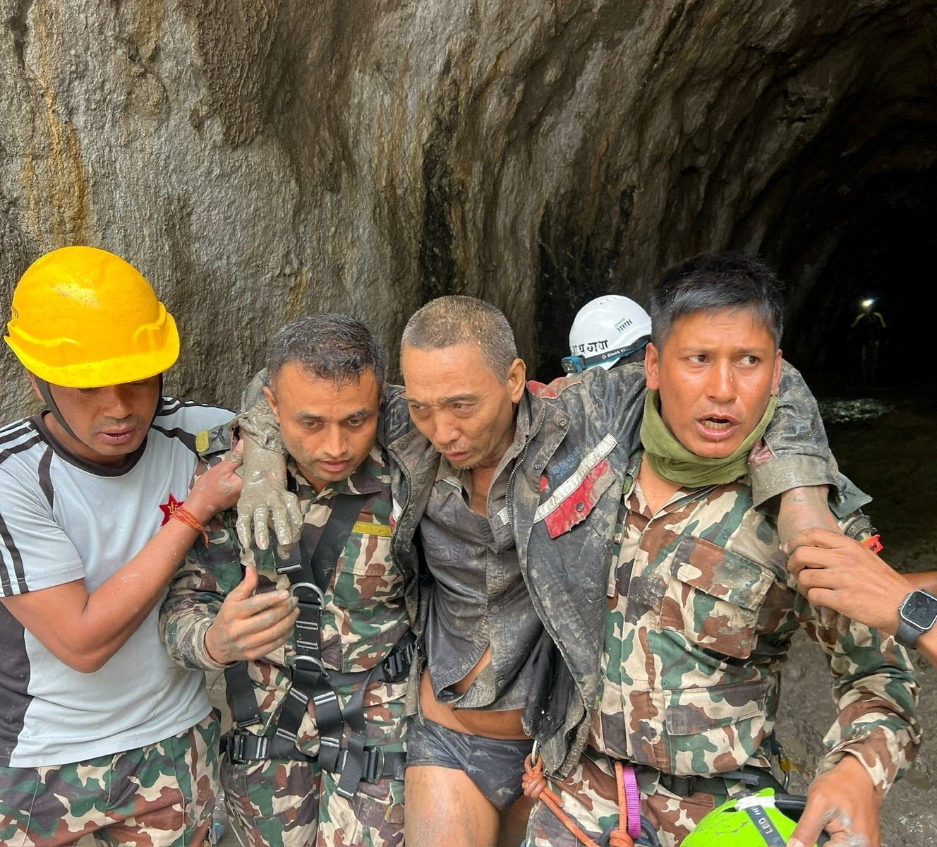 Members of the Nepal Army search and rescue team carry a Chinese national after he was rescued alive from a tunnel at the Upper Trishuli-1 Hydropower Project