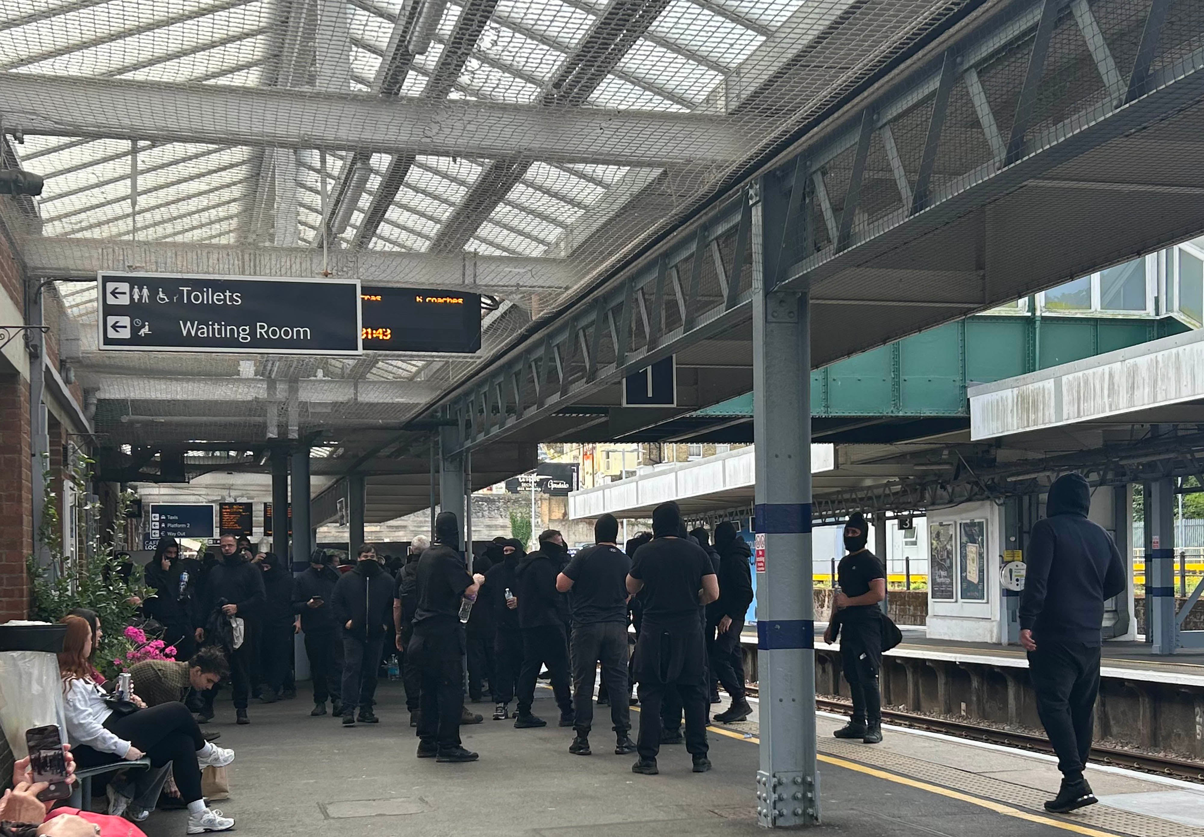 Protesters at Dover Priory train station after black-clad and masked anti-illegal migrant demonstrators blocked roads in Dover during a protest (PA)