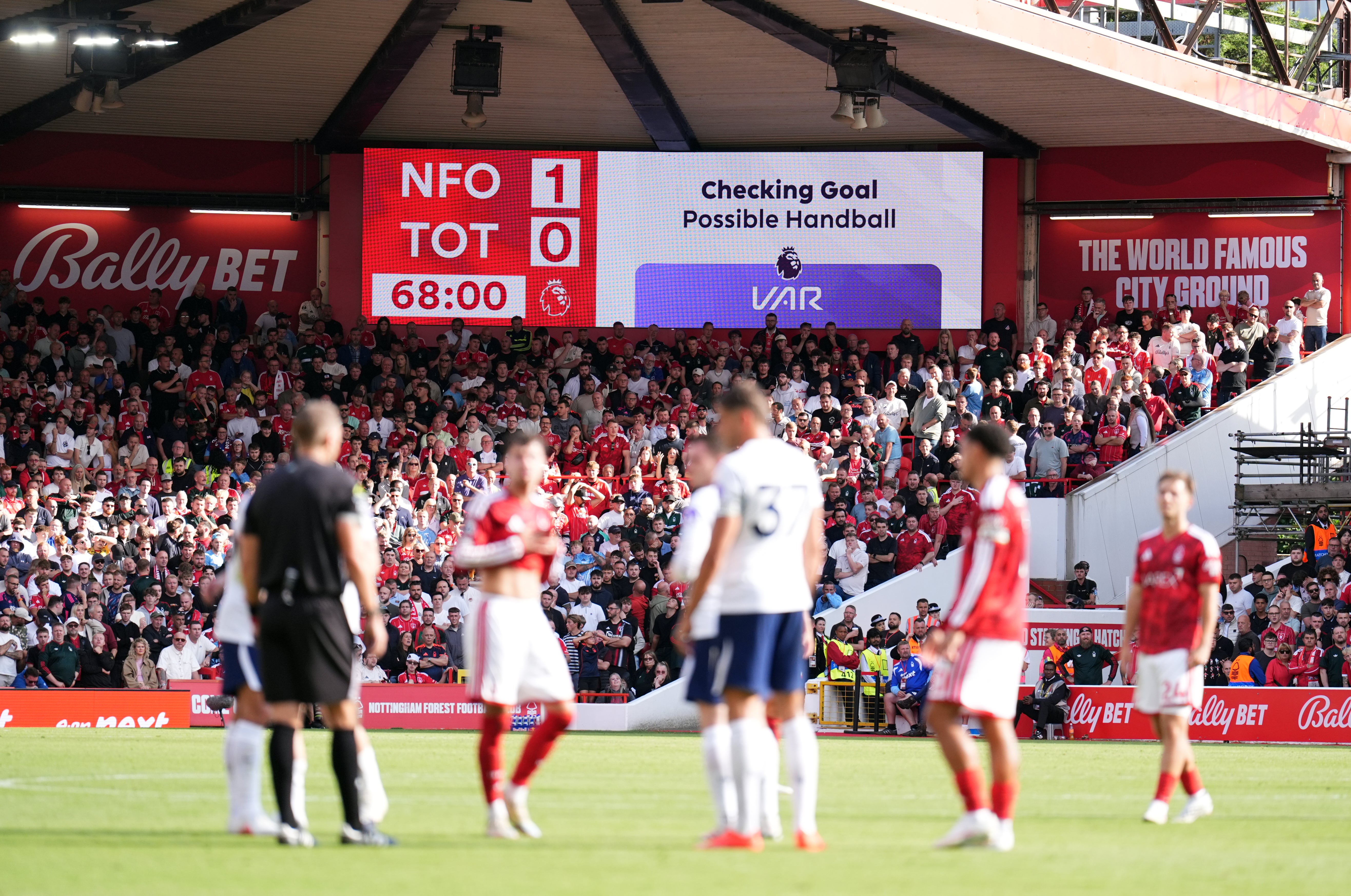 Players wait during a VAR check after Nottingham Forest's Neco Williams scored, only to be ruled out for handball