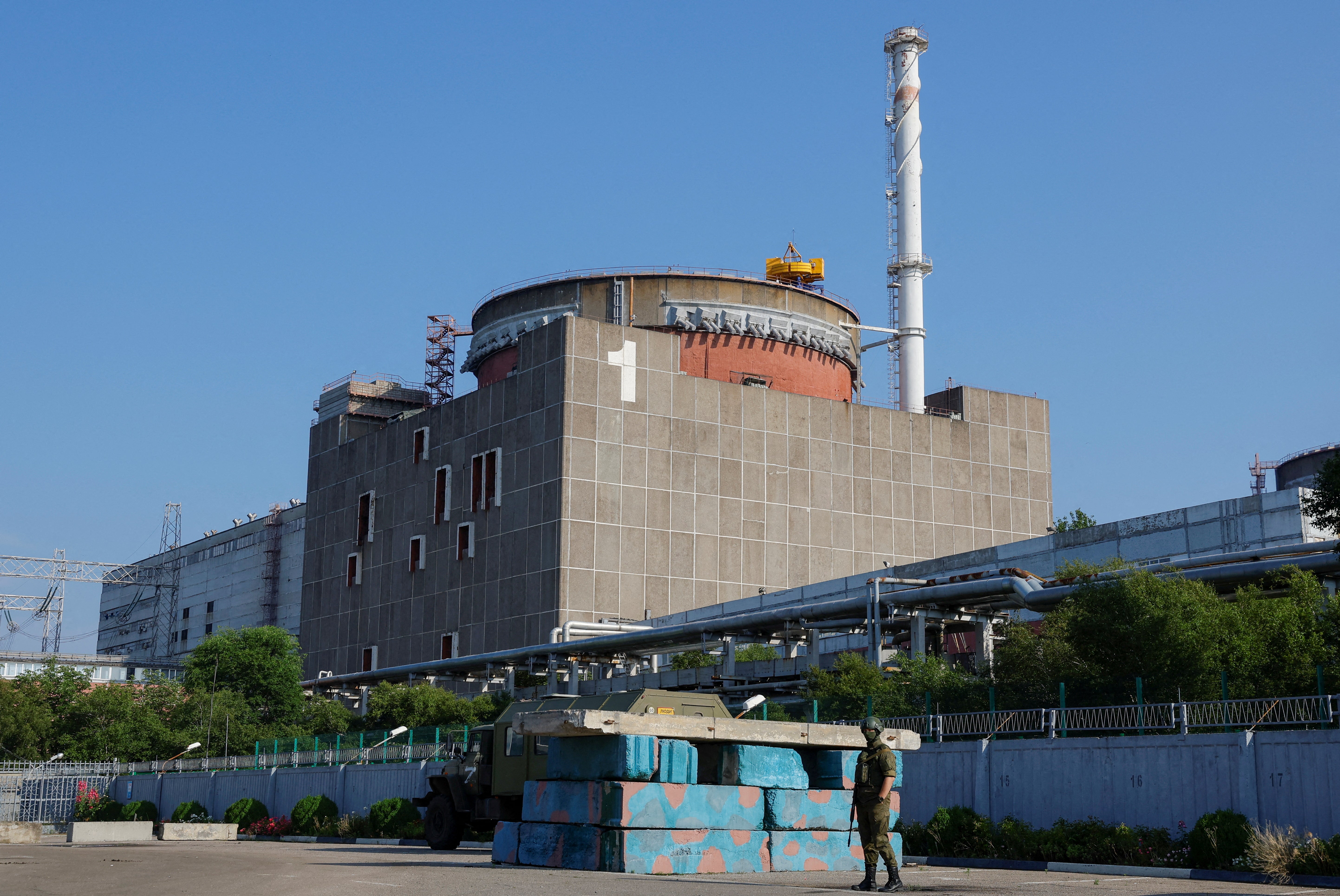 A Russian service member stands guard at a checkpoint near the Zaporizhzhia Nuclear Power
