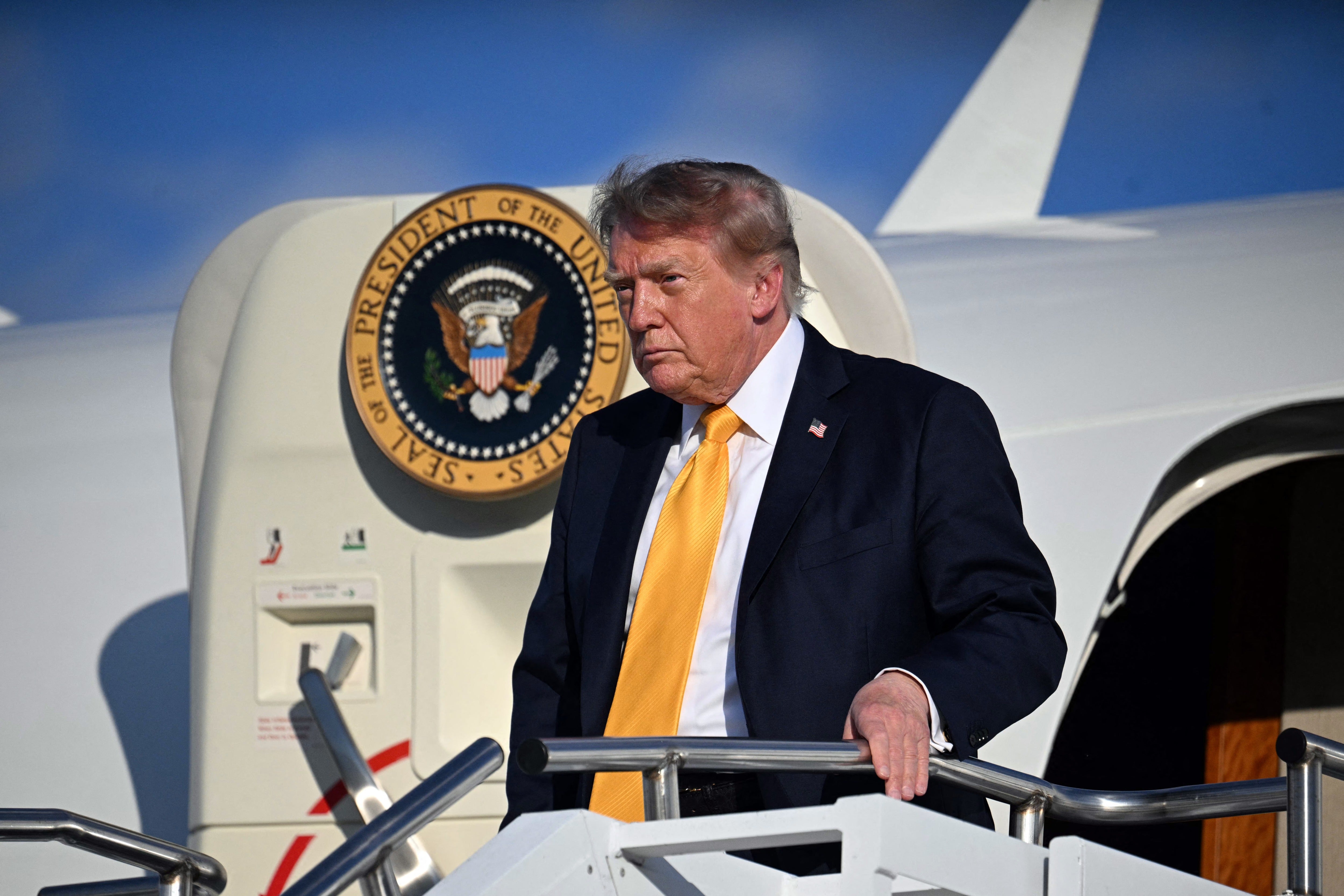 Trump was seen waving to reporters on the tarmac of an airport in Morristown, New Jersey, Friday, wearing a Navy suit and yellow tie — and, apparently, his new hairdo