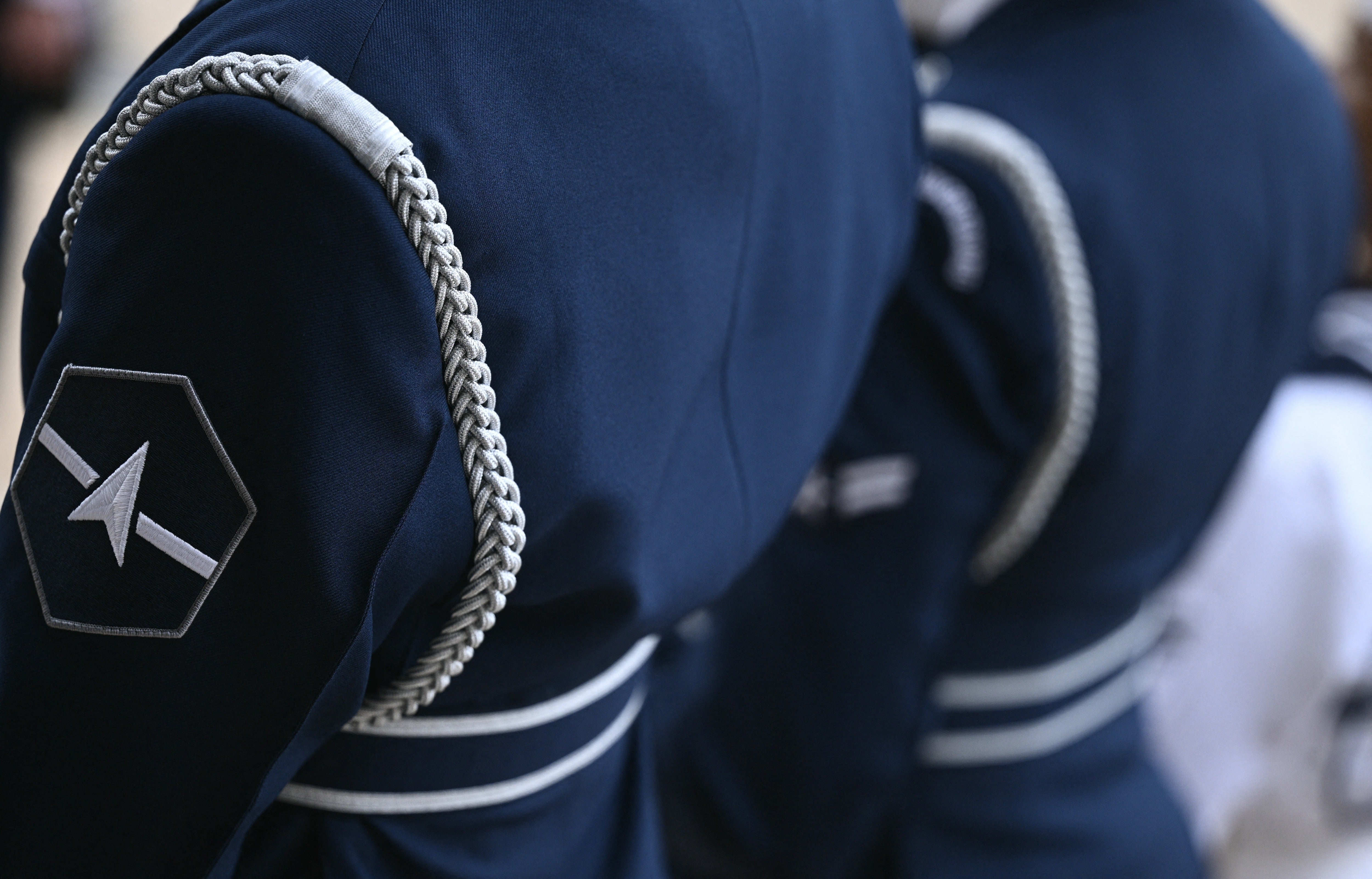 The new design includes a sleek, charcoal-colored collared jacket and pants compared to the current Navy blue uniforms