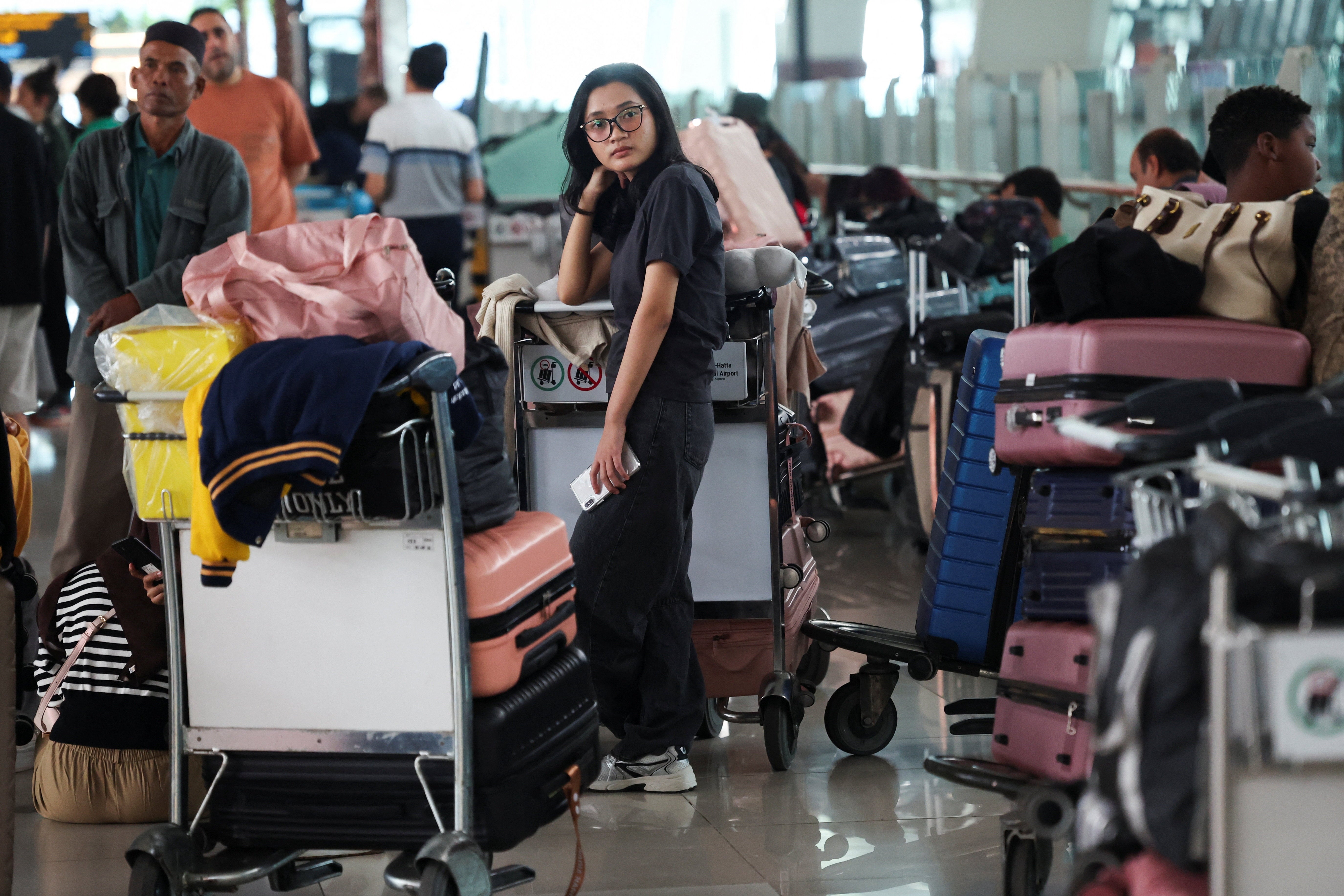 A stranded passenger looks on while at terminal as Soekarno-Hatta International Airport closed its operations due to the eruption of the Mount Anak Krakatau volcano, in Tangerang