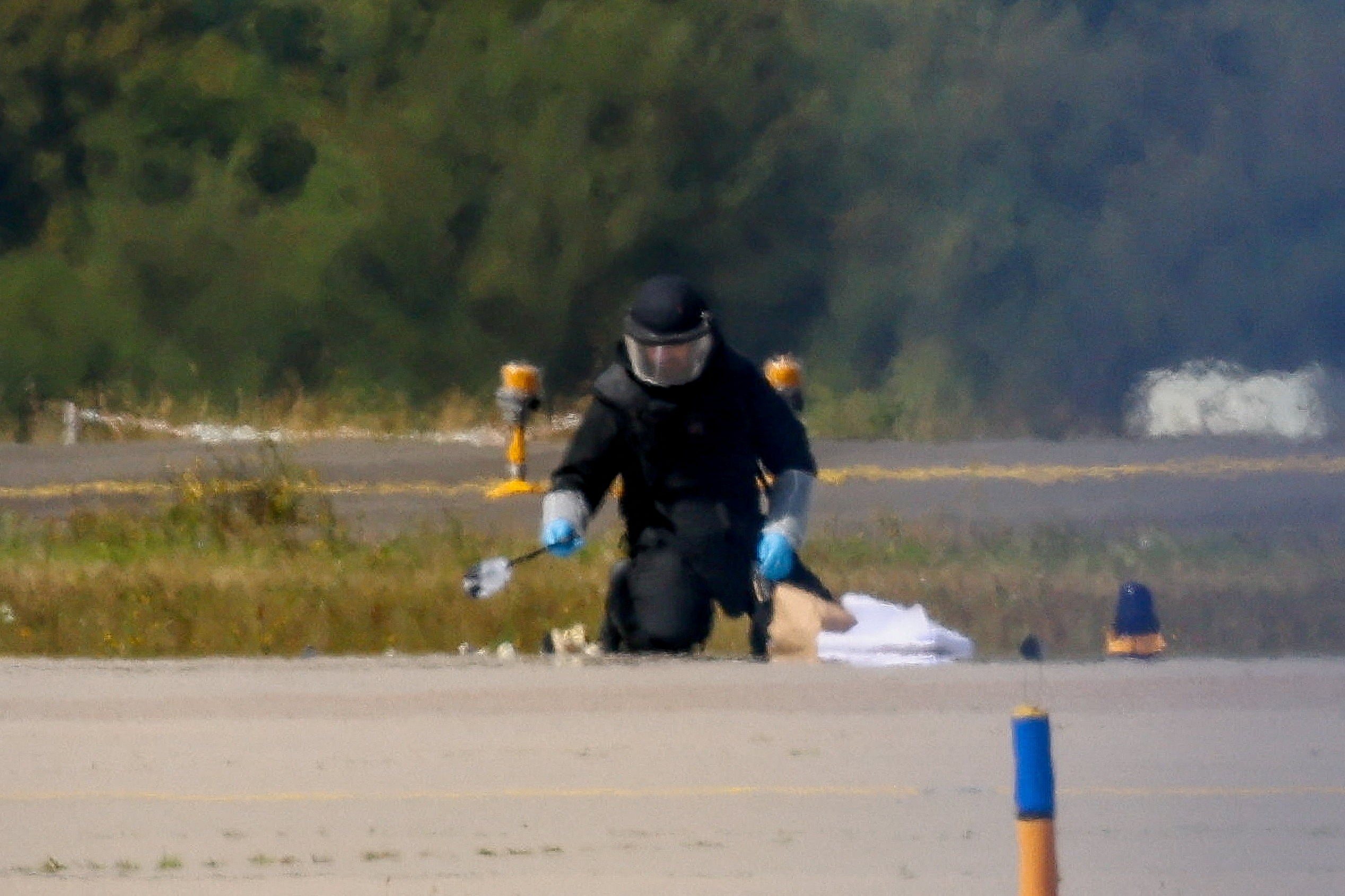 A police officer in protective clothing works during the drone incident at Leipzig/Halle Airport on 5 August (Reuters)