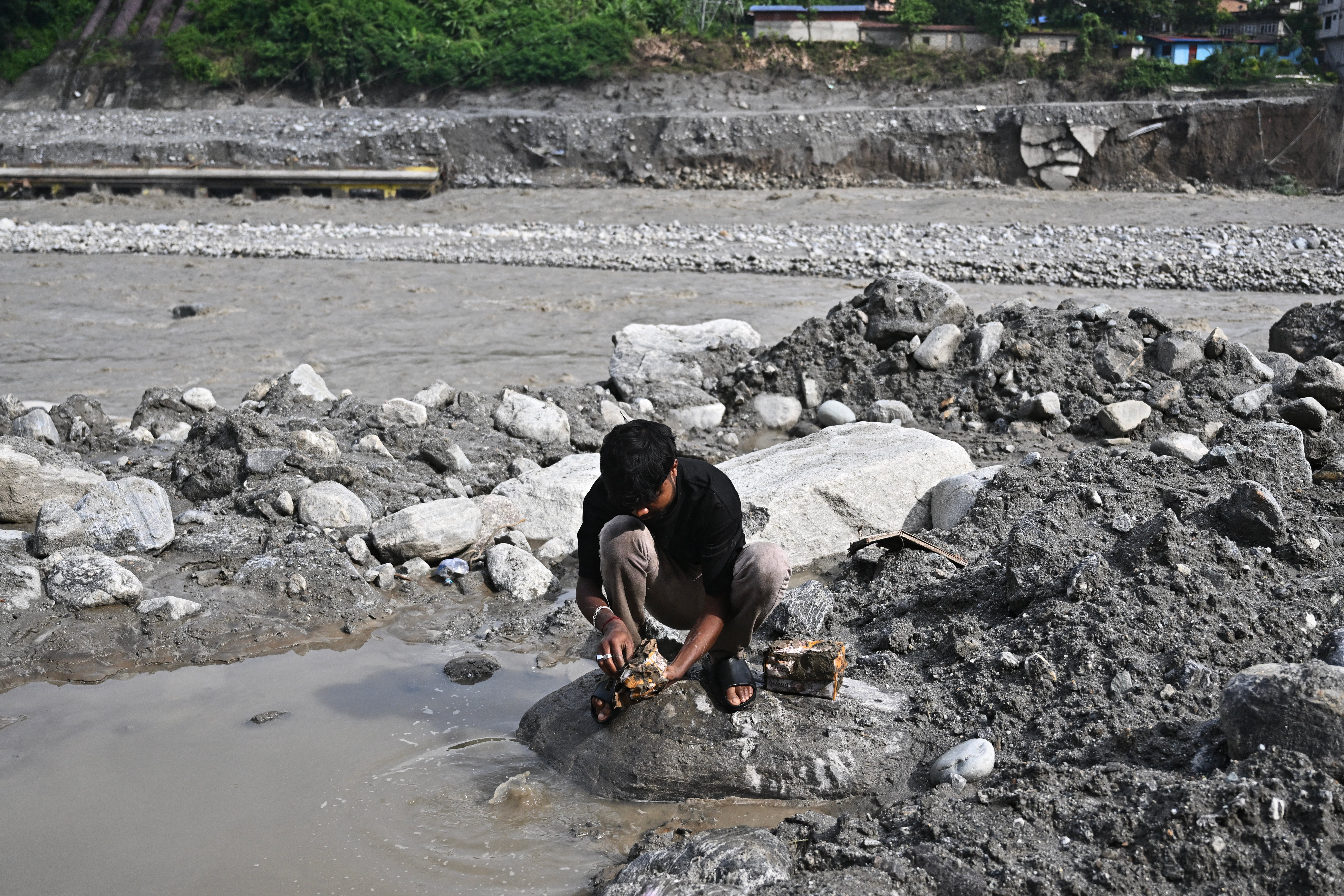 A man tries to recover his belongings in the aftermath of flash floods at Trishuli in Nepal's Nuwakot district on 7 September 2026