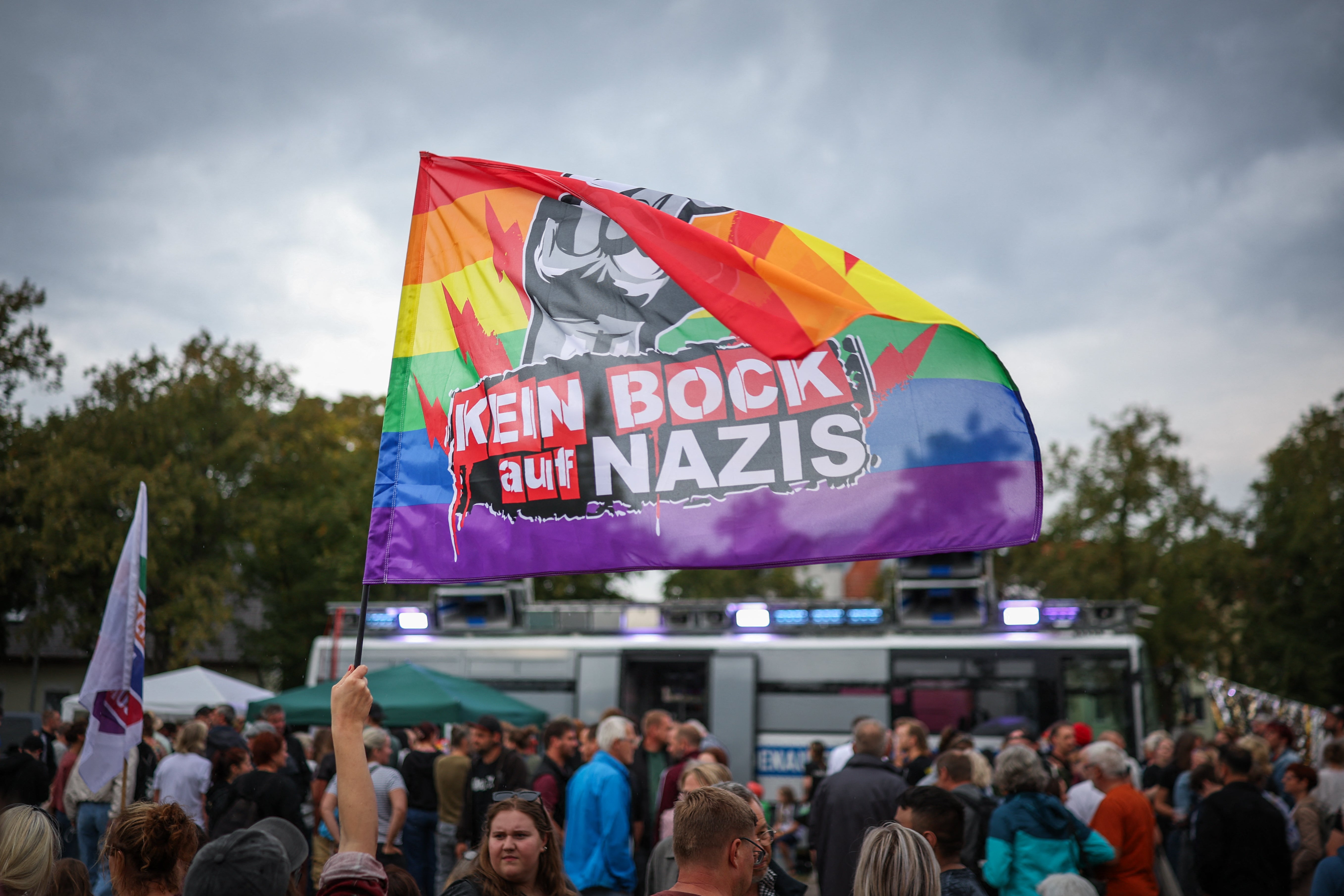 A participant in a counter-demonstration against the far-right AfD is waves a flag that reads 