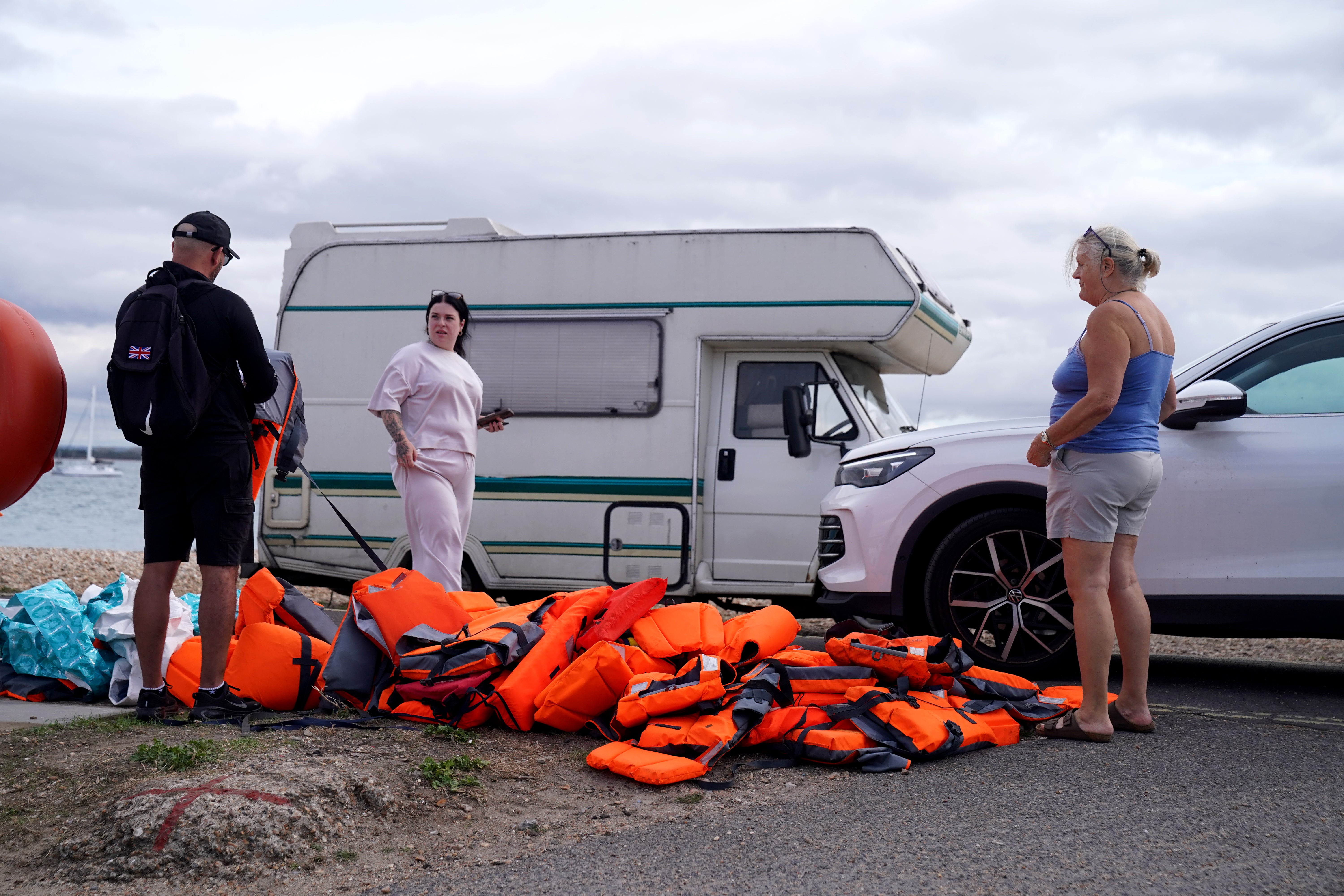 Local resident Sue Dewey (right), 68, collects some of the discarded life jackets at Eastney Point