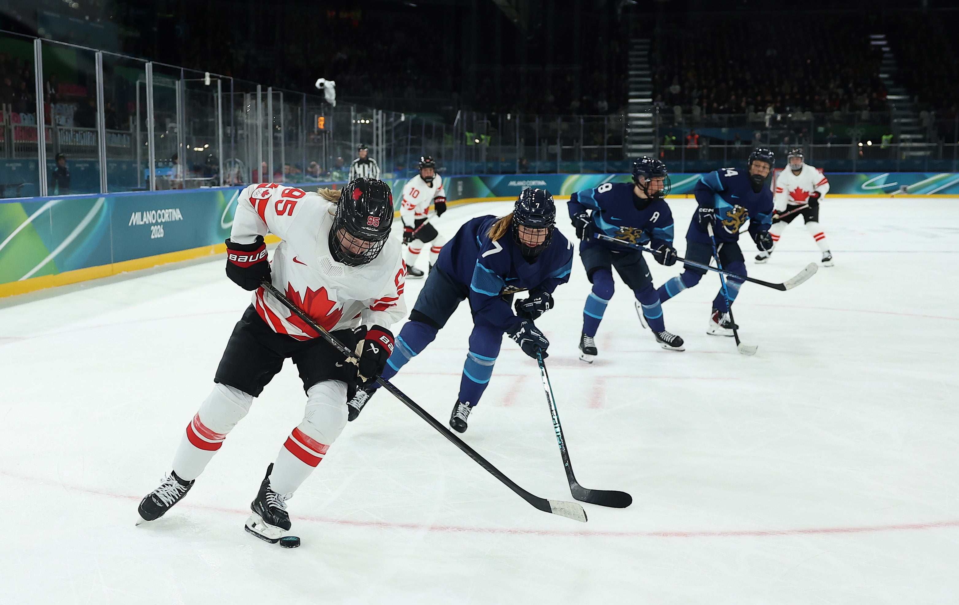 Daryl Watts #95 of Team Canada skates with the puck through a stick check by Sanni Rantala #7 of Team Finland in the third period during the Women's Preliminary Group A match between Finland and Canada on day six of the Milano Cortina 2026 Winter Olympic games at Milano Rho Ice Hockey Arena
