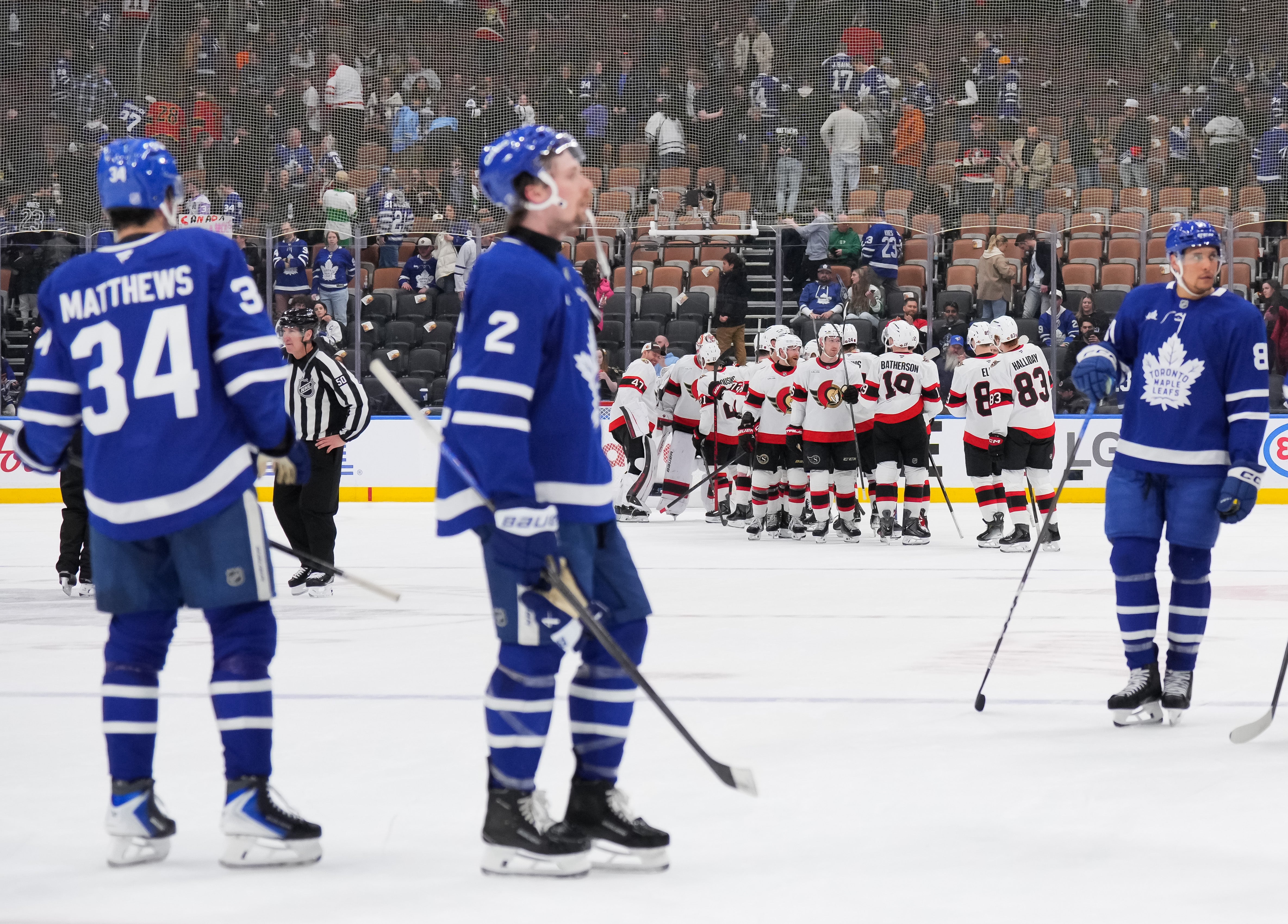 The Ottawa Senators celebrate after a 5-2 win as the Toronto Maple Leafs skate off the ice at Scotiabank Arena