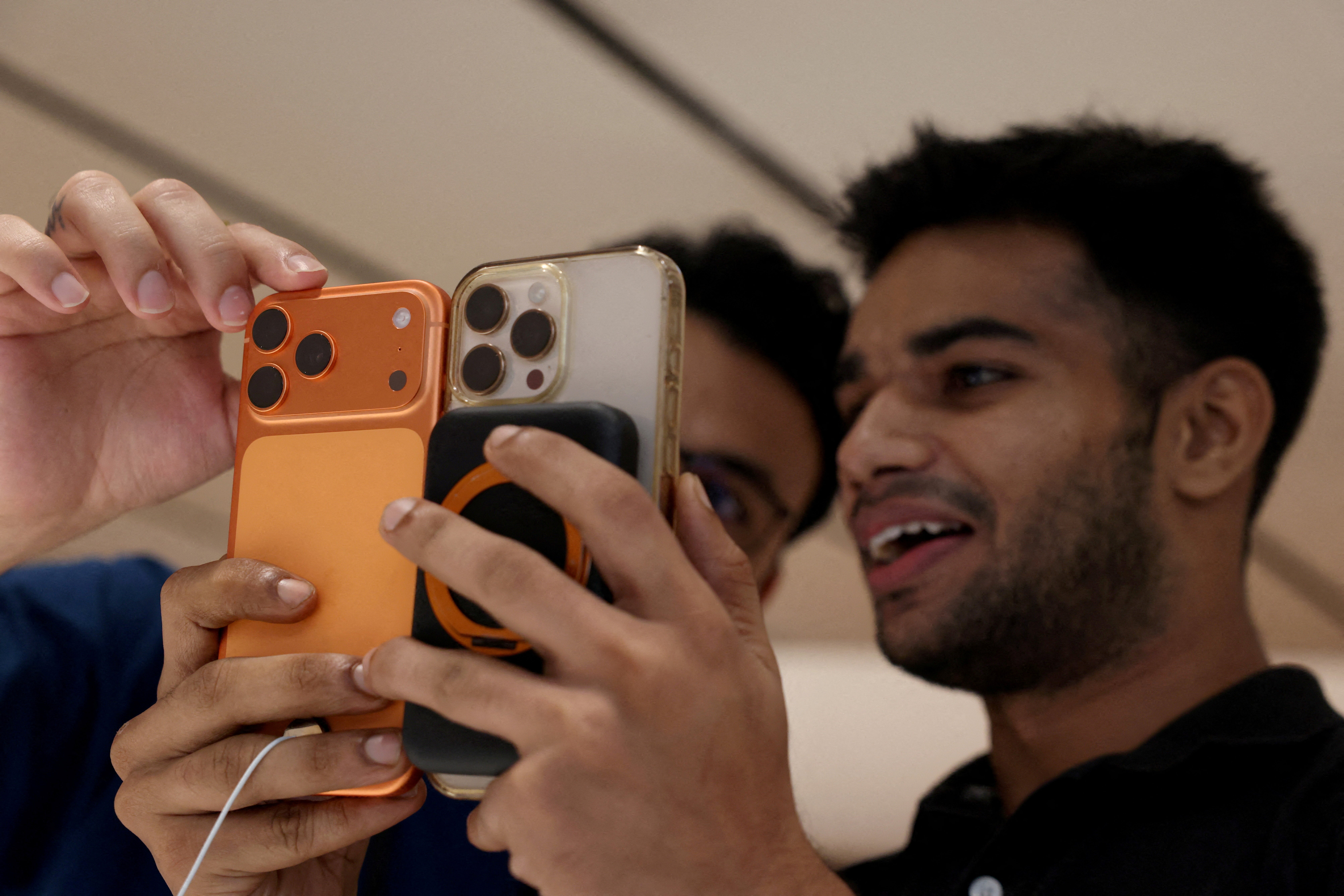A customer compares his old iPhone with the newly launched iPhone 17 pro max at an Apple retail store in Delhi, India, September 19, 2025