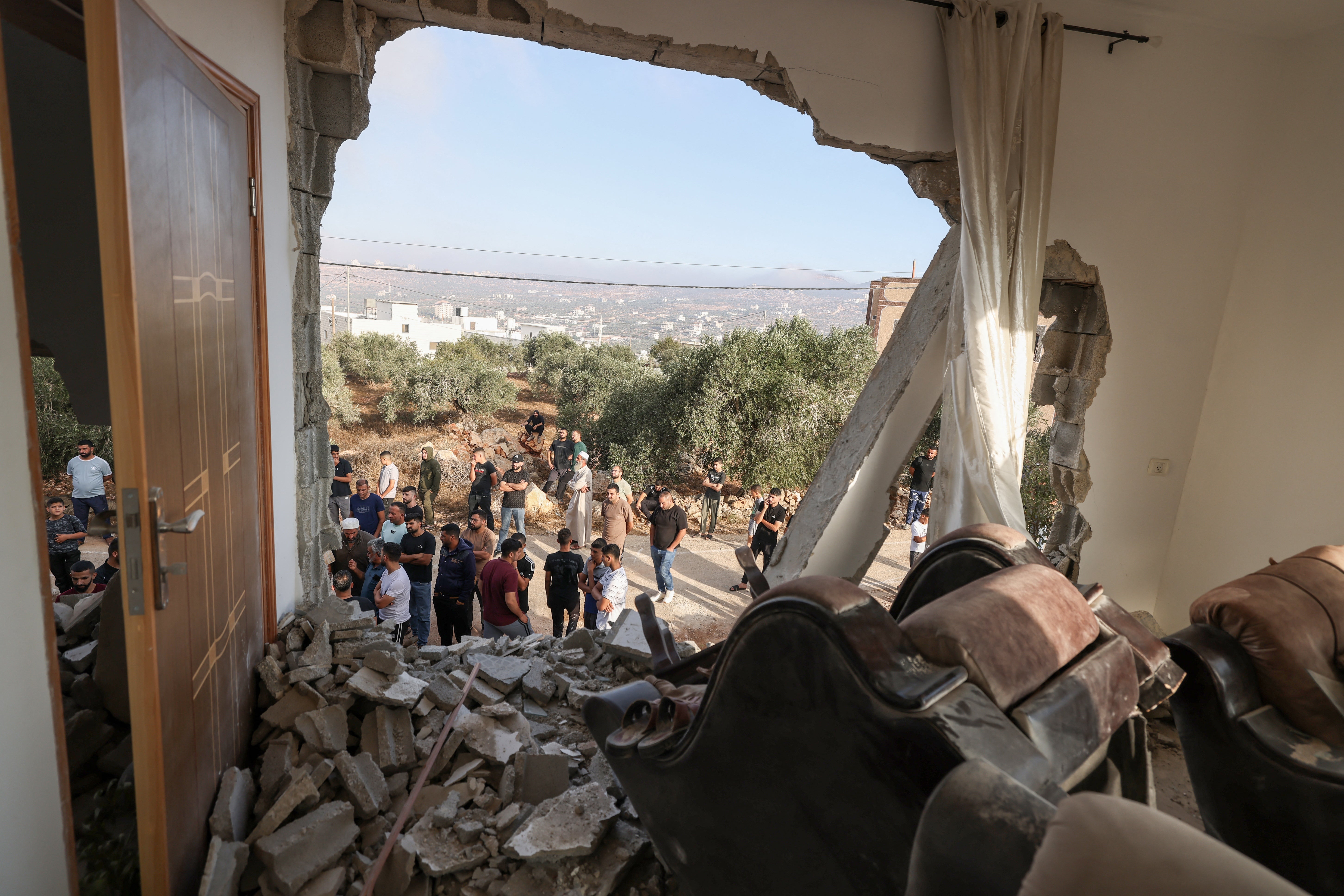 Palestinians inspect a family home destroyed by the Israel army following a military operation after a Palestinian man barricaded himself inside the house in the Israel-occupied West Bank village of Aqraba, south of the city of Nablus on September 8, 2026.