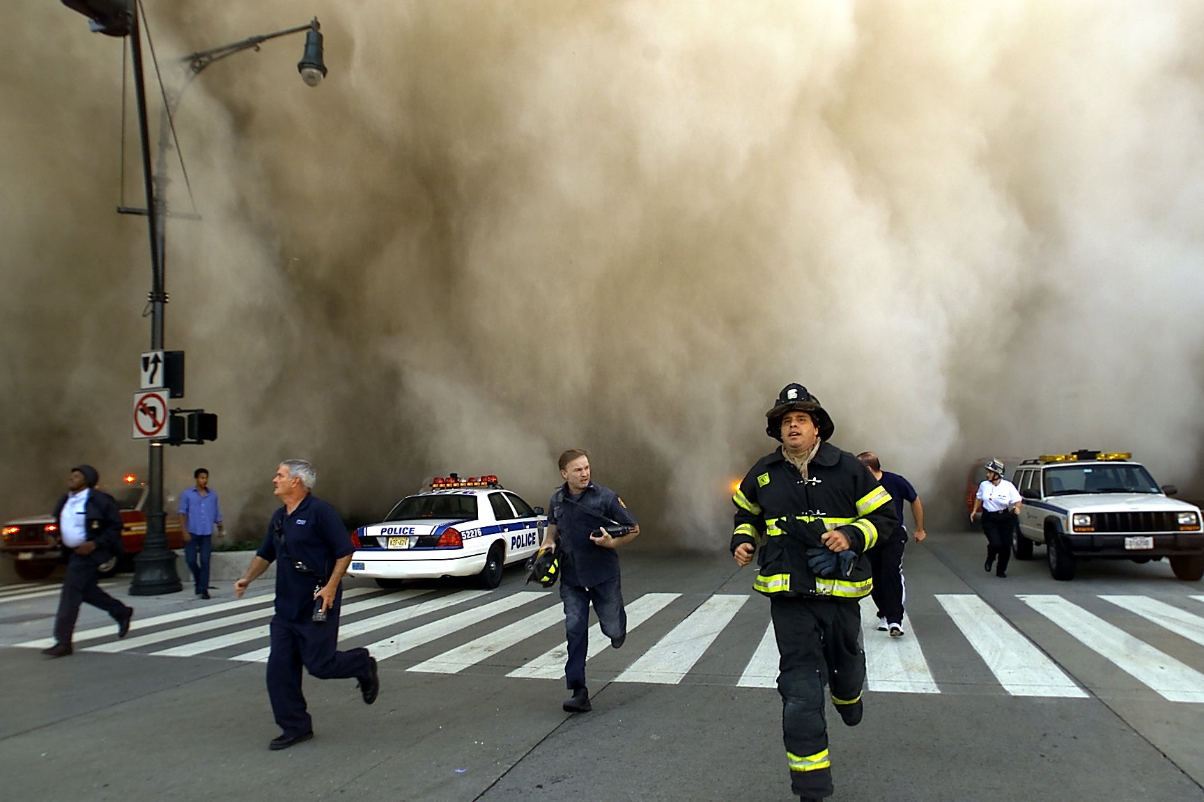 First responders try to outrun a dust cloud caused by the collapse of the World Trade Center’s north tower on September 11, 2001