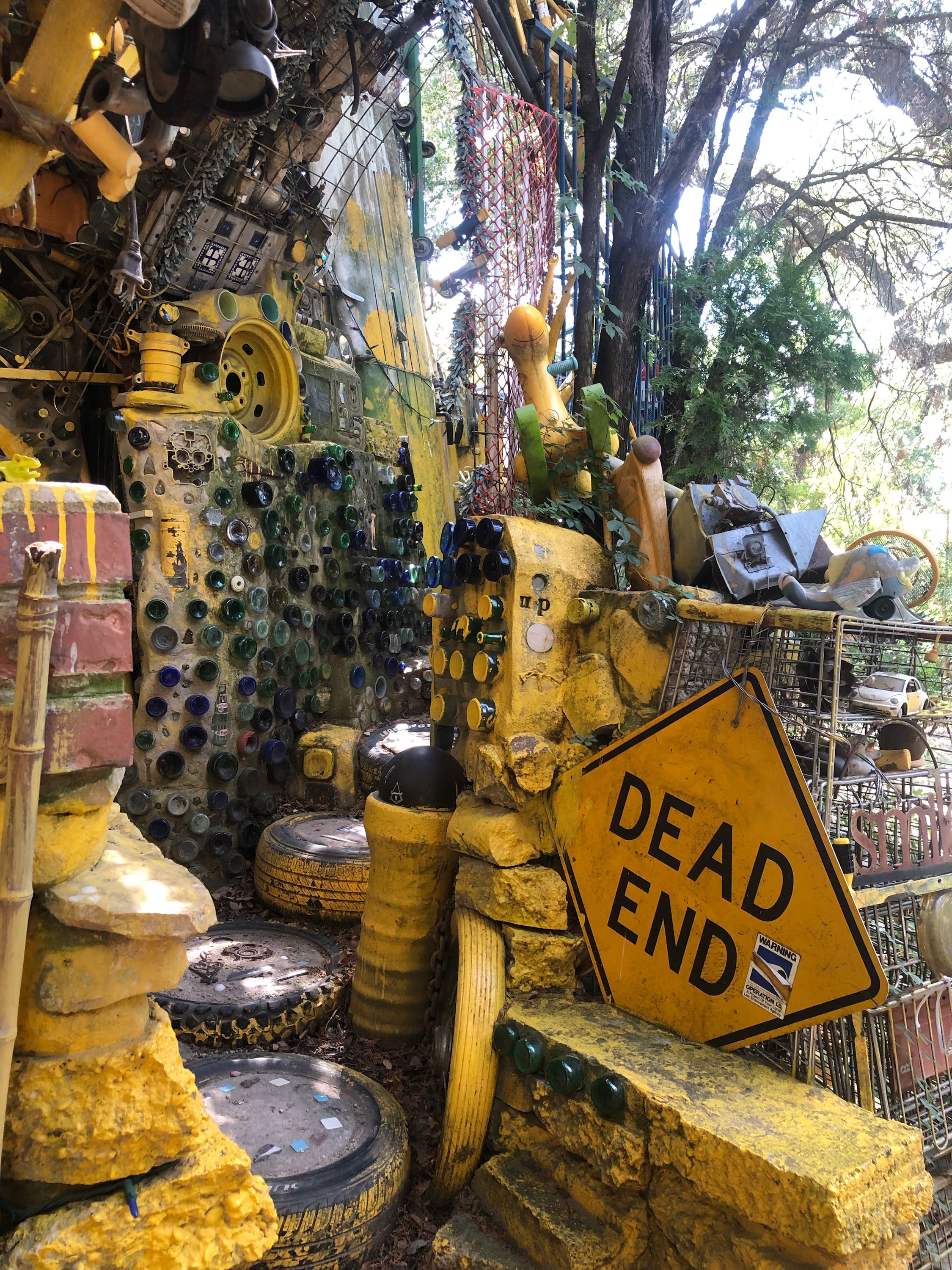 Inside the Cathedral of Junk, dozens of glass bottles poke through the partial cement walls, and light shines through the top of the structure’s frame