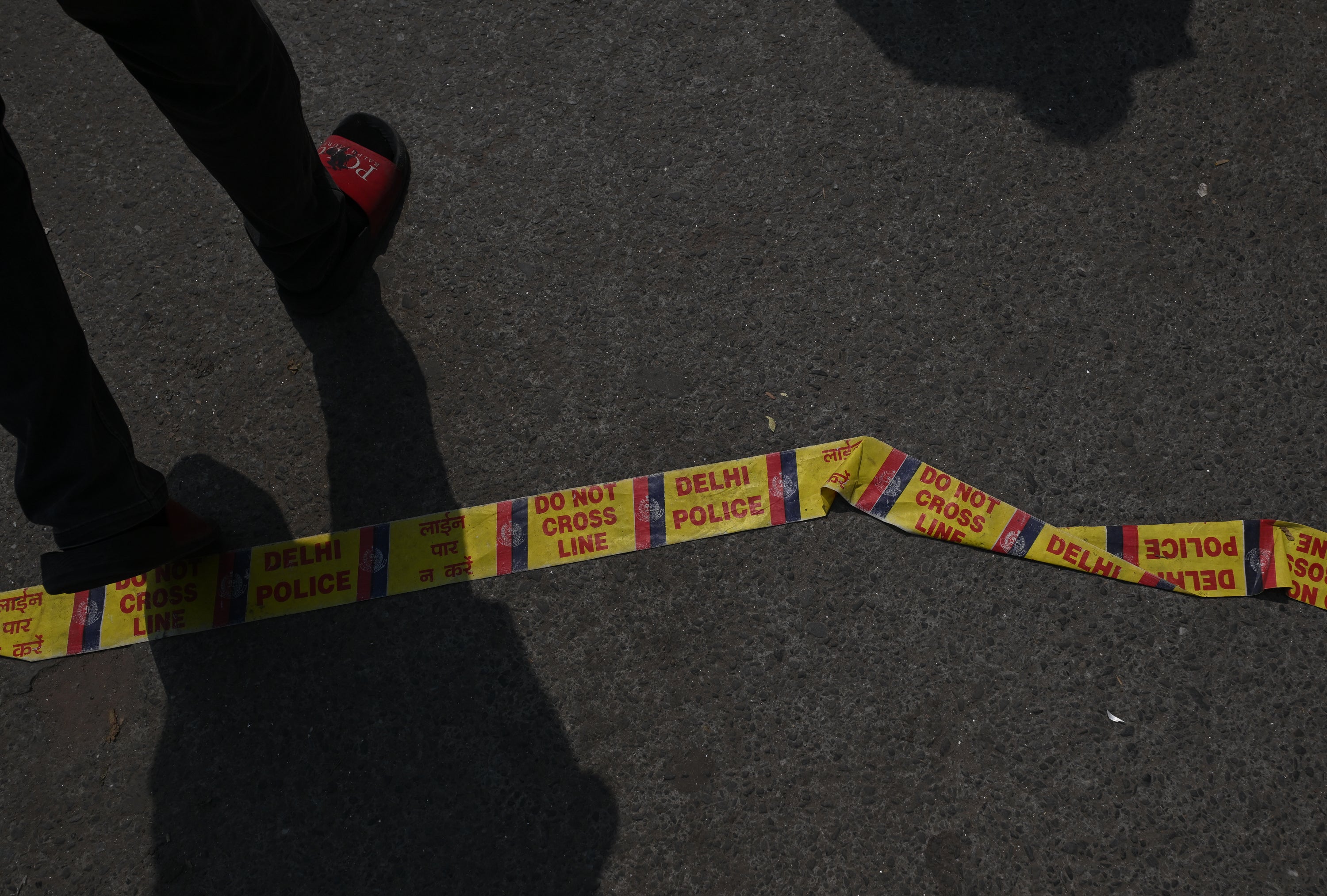 Local people cross police tape on the ground outside of a building following a fire at a restaurant on June 03, 2026 in New Delhi, India.