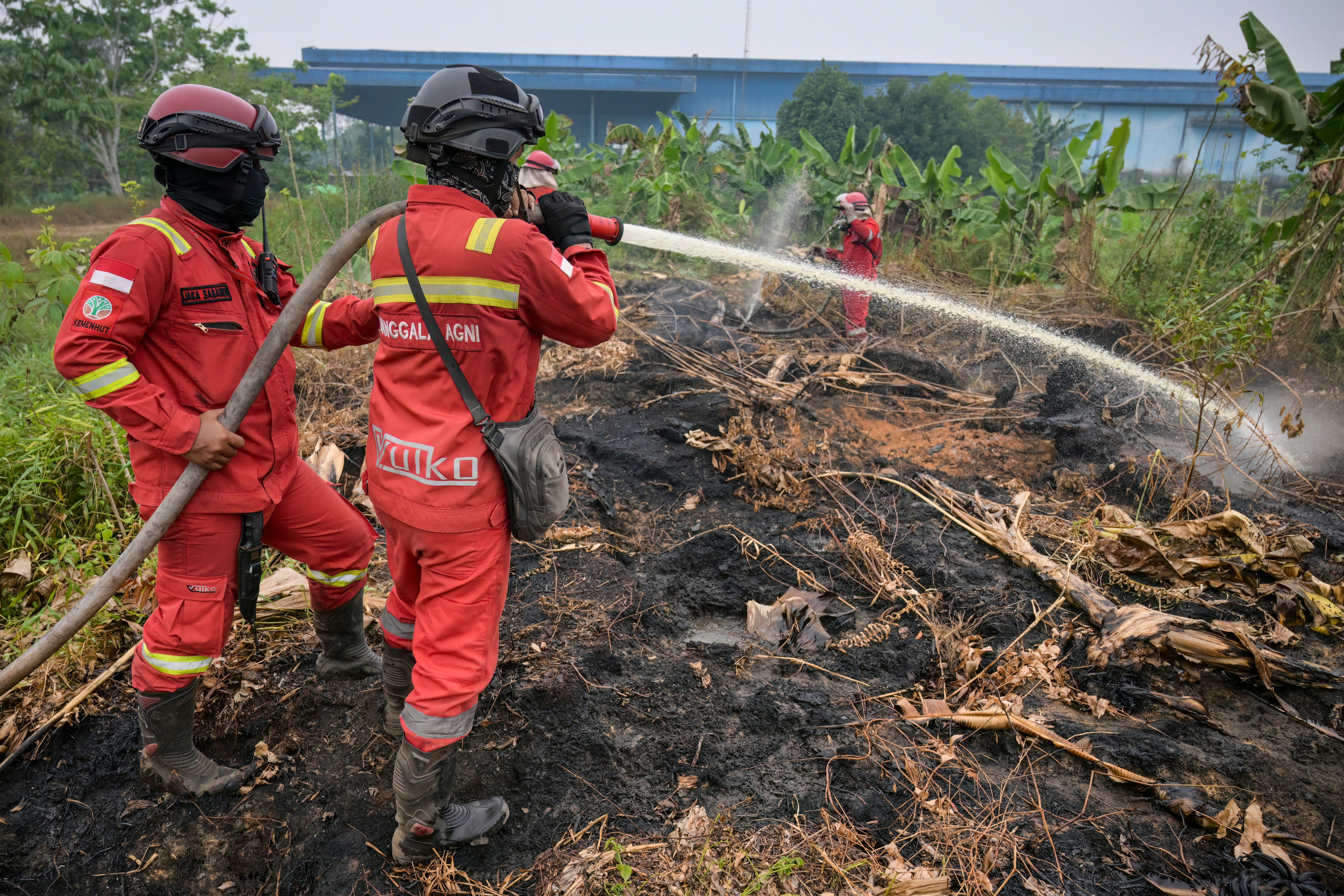 Forestry department firefighters extinguish a ground fire at Kuala Dua village in Kubu Raya, West Kalimantan, on 6 September 2026 (AFP/Getty)